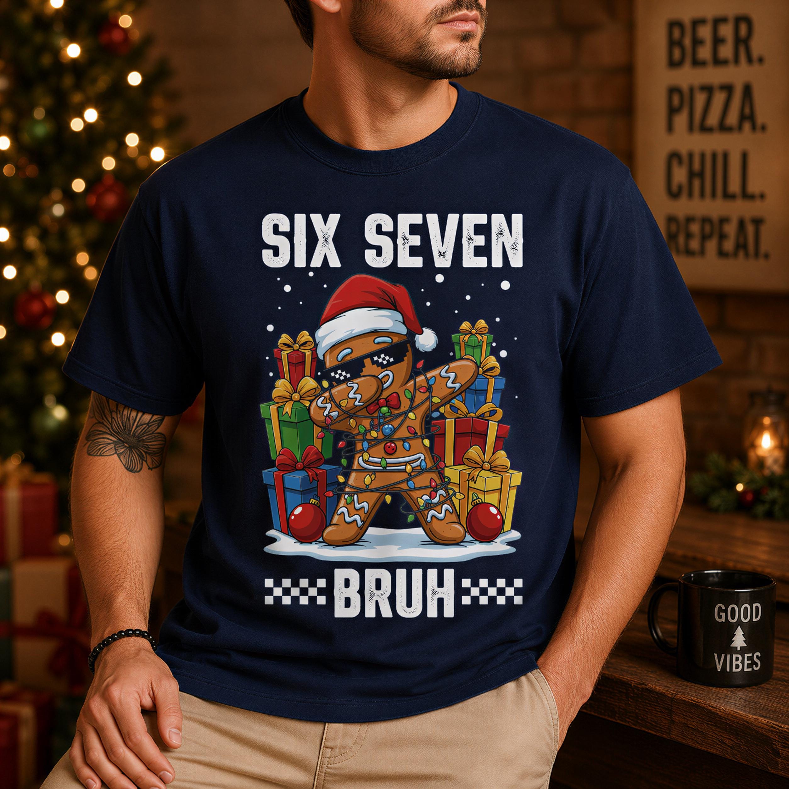 A man wearing a navy blue t-shirt with a graphic design of a gingerbread man wearing sunglasses and holding presents, with the text "Six Seven Bruh" and "Good Vibes" printed on it.