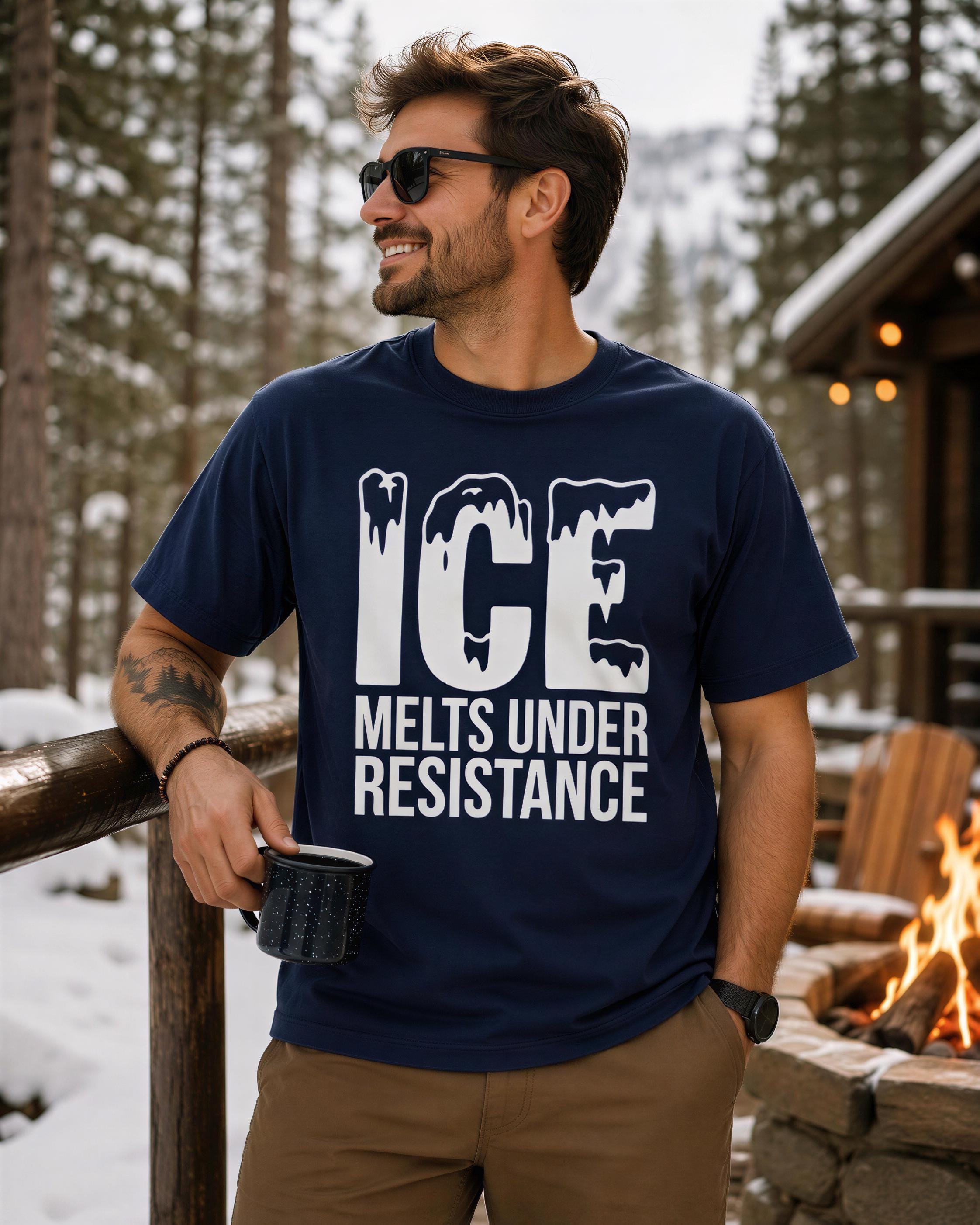 A man wearing a navy blue t-shirt with the text "ICE MELTS UNDER RESISTANCE" is standing in front of a snowy forest, holding a mug and smiling.