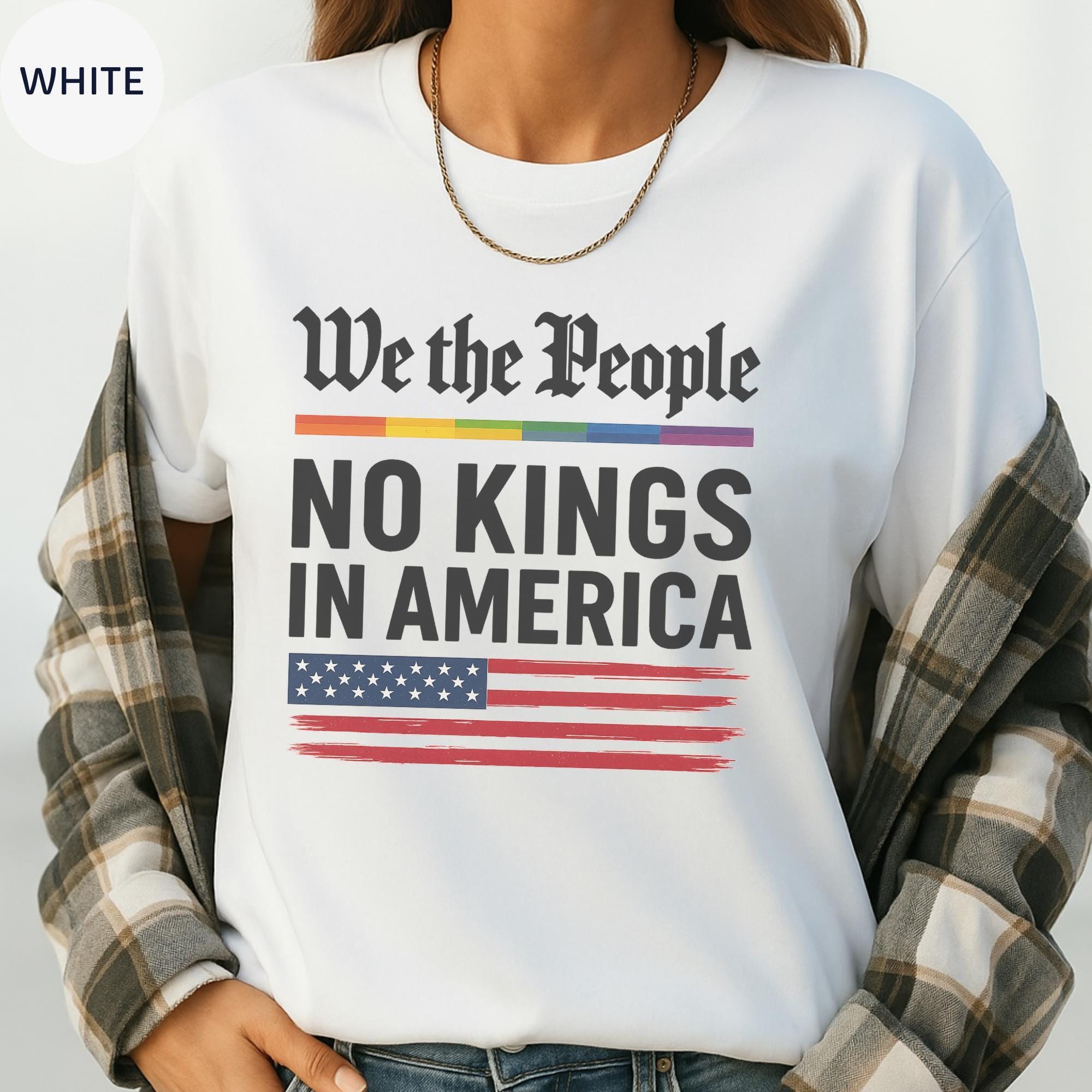 A white t-shirt with the text "We the People NO KINGS IN AMERICA" printed on it, along with an American flag design.