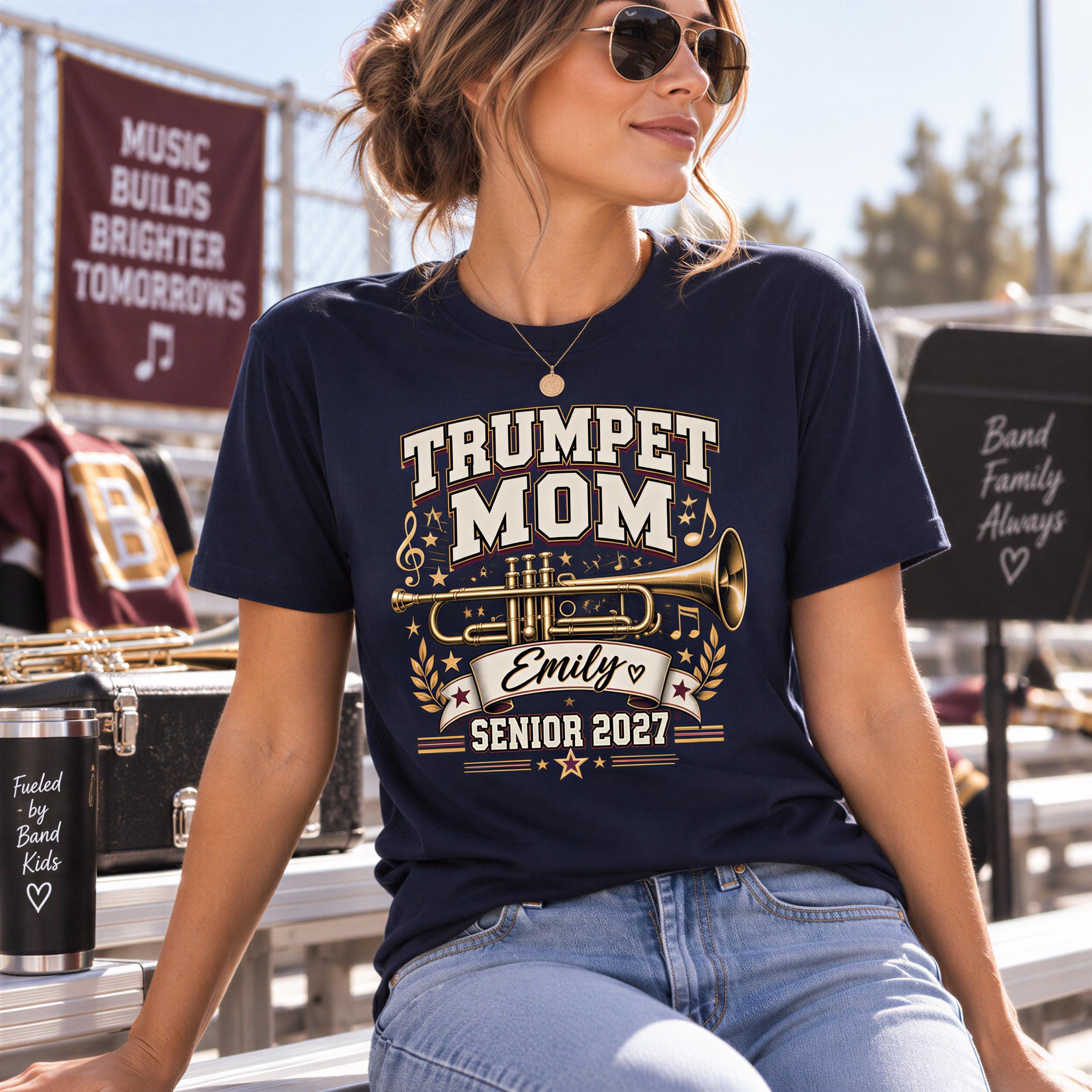 A woman wearing a navy blue t-shirt with a trumpet design and text, sitting on a bench.