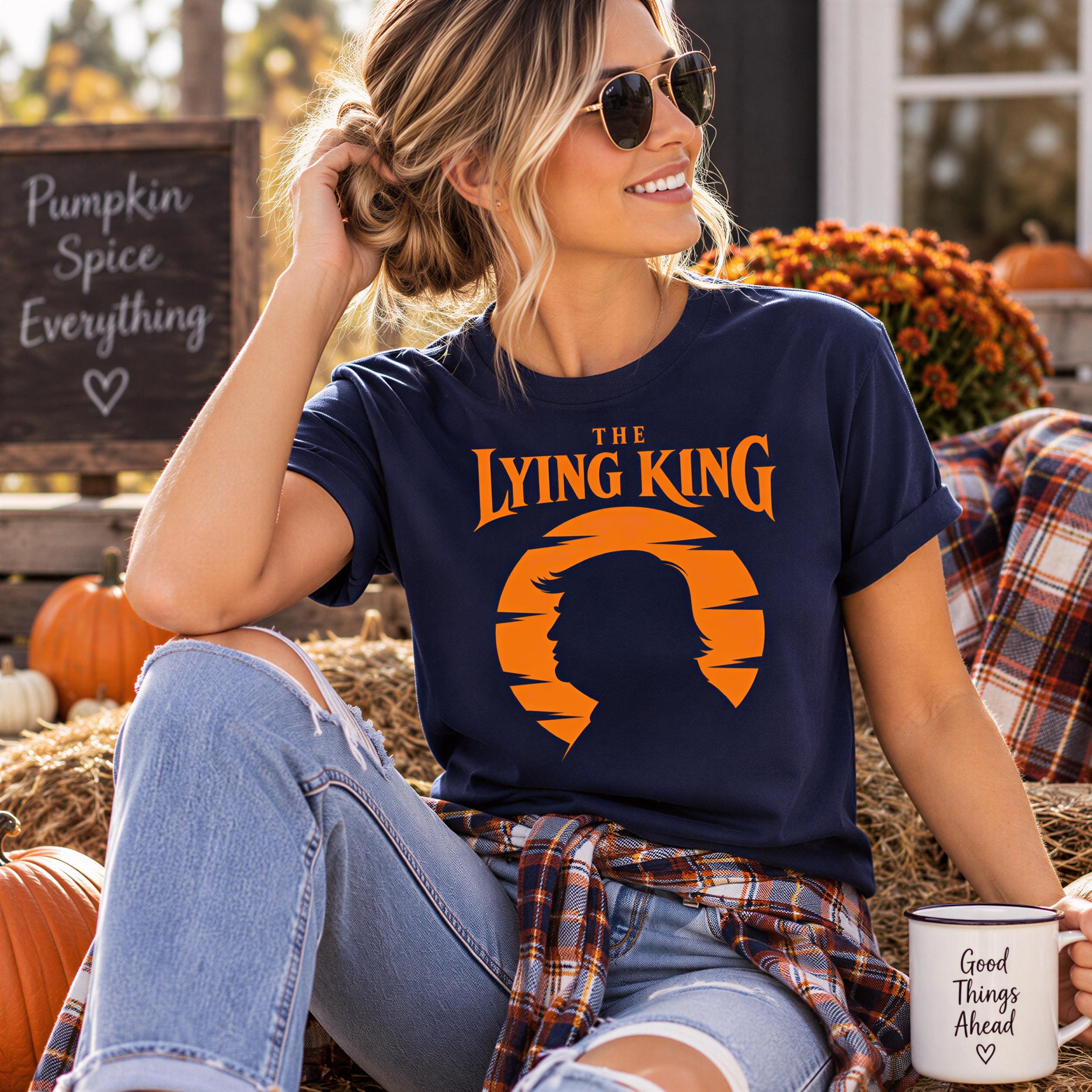 A woman wearing sunglasses and a t-shirt with a graphic design is sitting on hay bales, holding a coffee mug, and smiling.