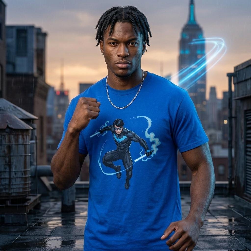 A man wearing a blue t-shirt with a graphic of a superhero character is standing in front of a city skyline at sunset.