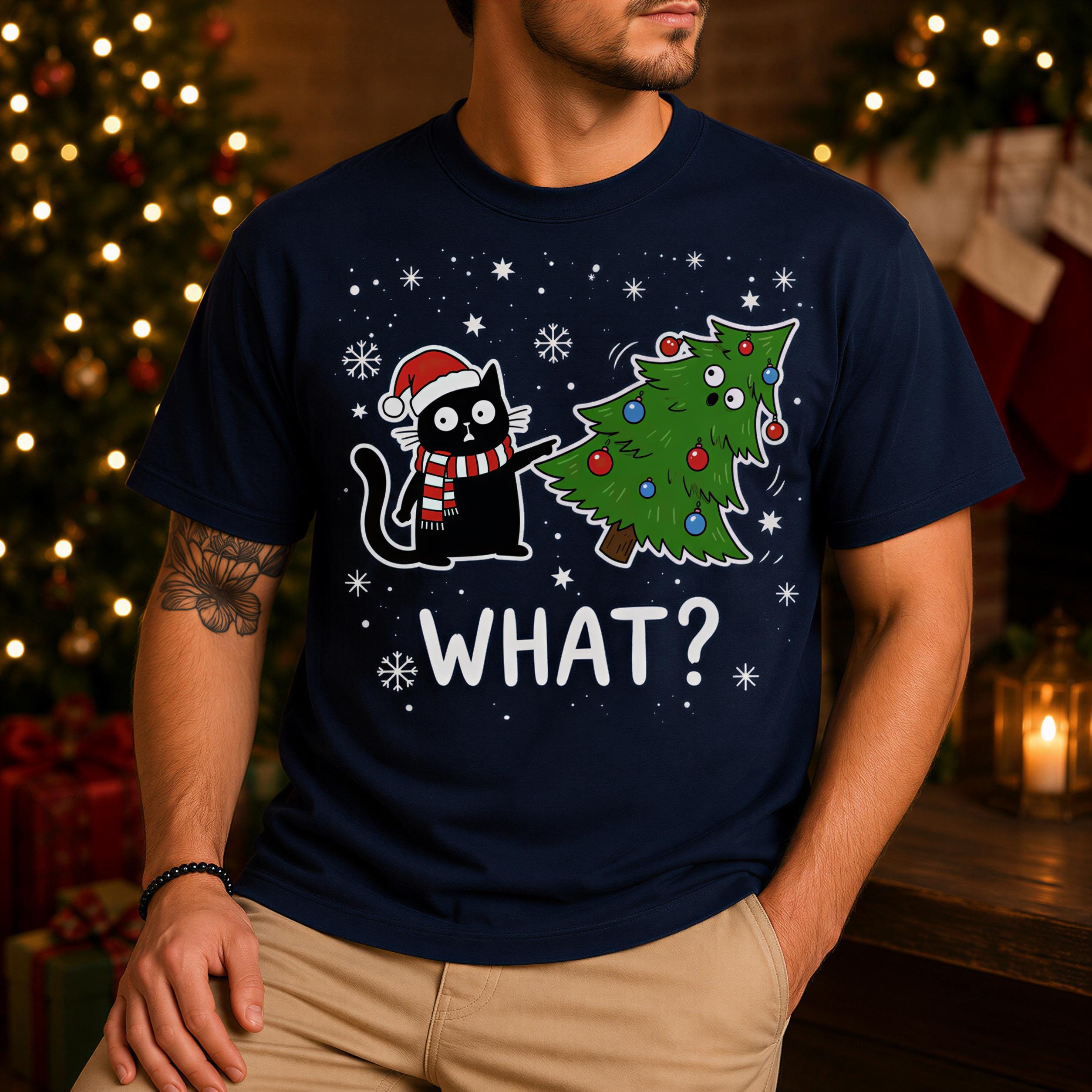 A man wearing a navy blue t-shirt with a graphic design featuring a cat and a Christmas tree, along with the text "WHAT?"