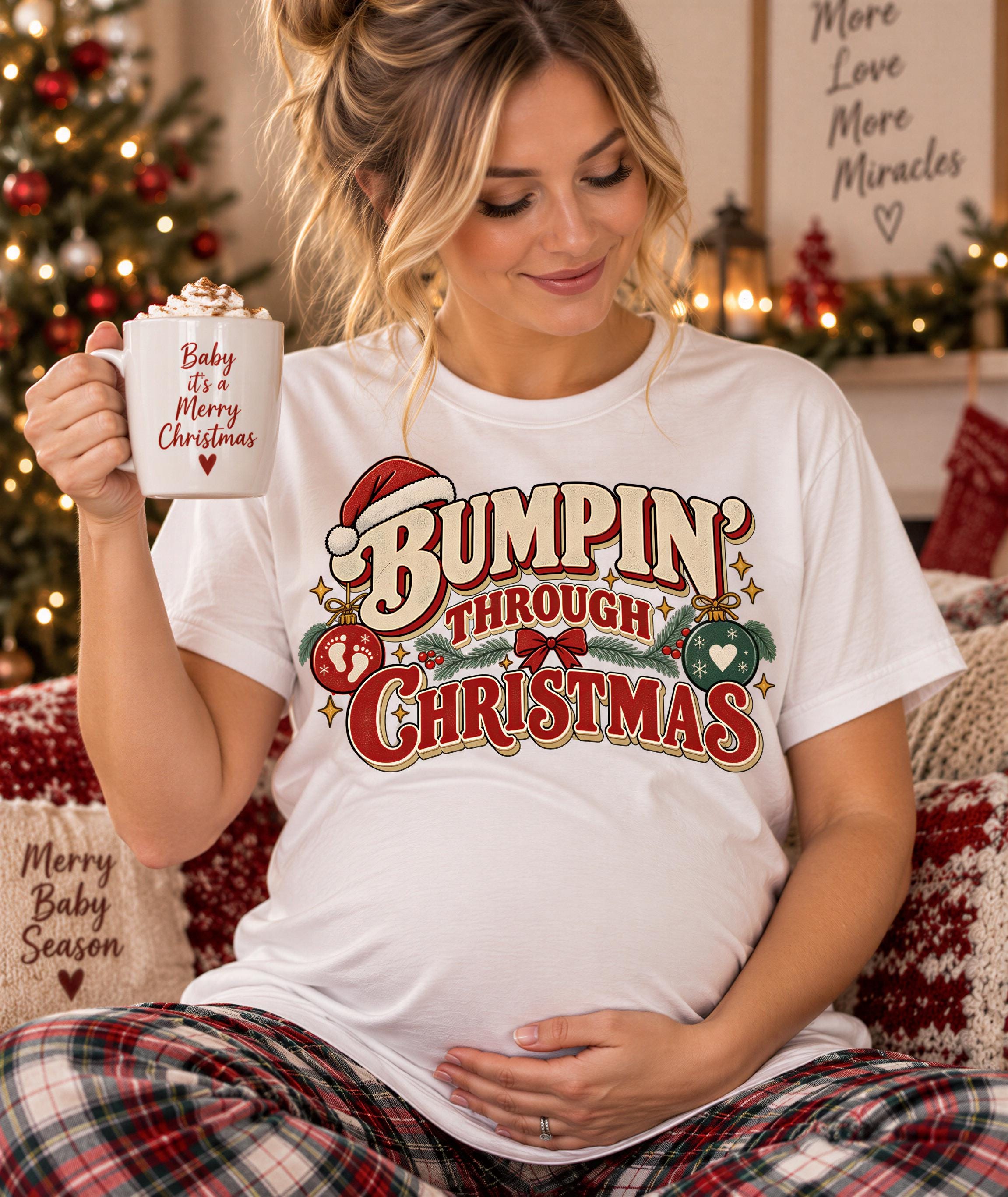 A pregnant woman wearing a white t-shirt with a Christmas-themed design is holding a mug with the text "Baby it's a Merry Christmas" written on it.