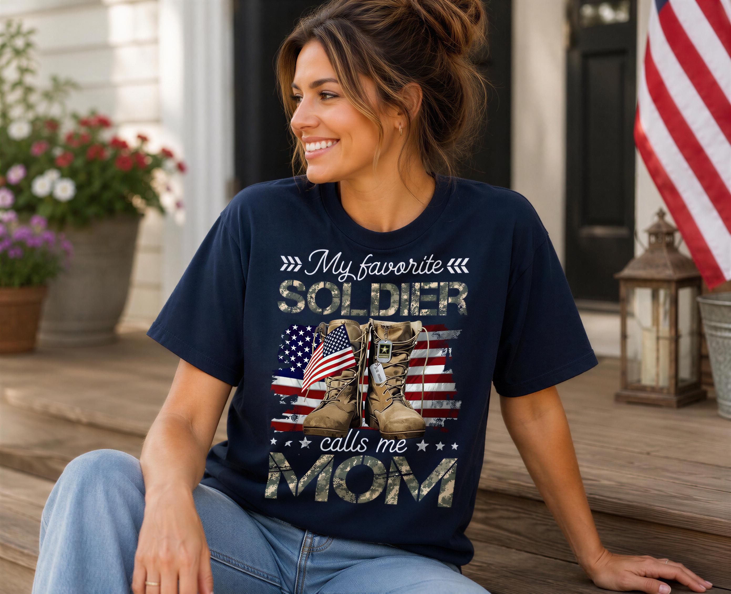 A woman wearing a navy blue t-shirt with a design of a soldier's boots and an American flag, sitting on a porch with a smiling expression.