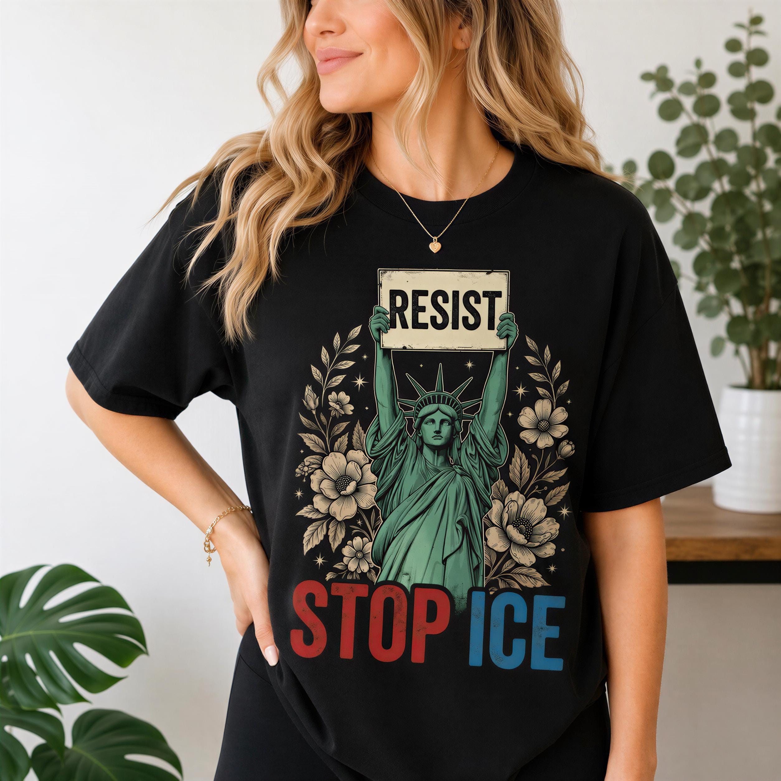 A woman wearing a black t-shirt with a graphic design featuring the Statue of Liberty and the text "RESIST STOP ICE".