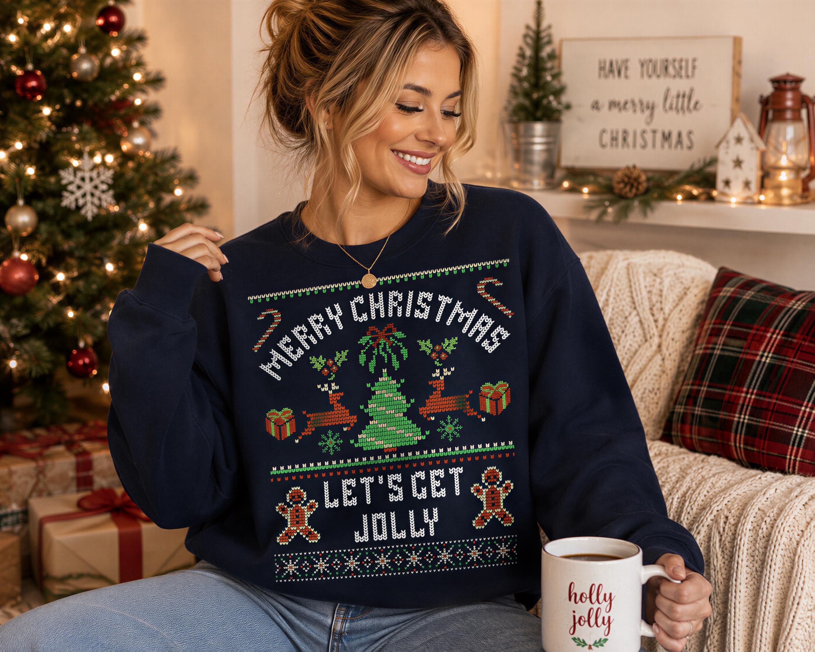 A woman wearing a navy blue sweater with a Christmas-themed design is sitting on a couch, holding a mug of coffee and smiling.