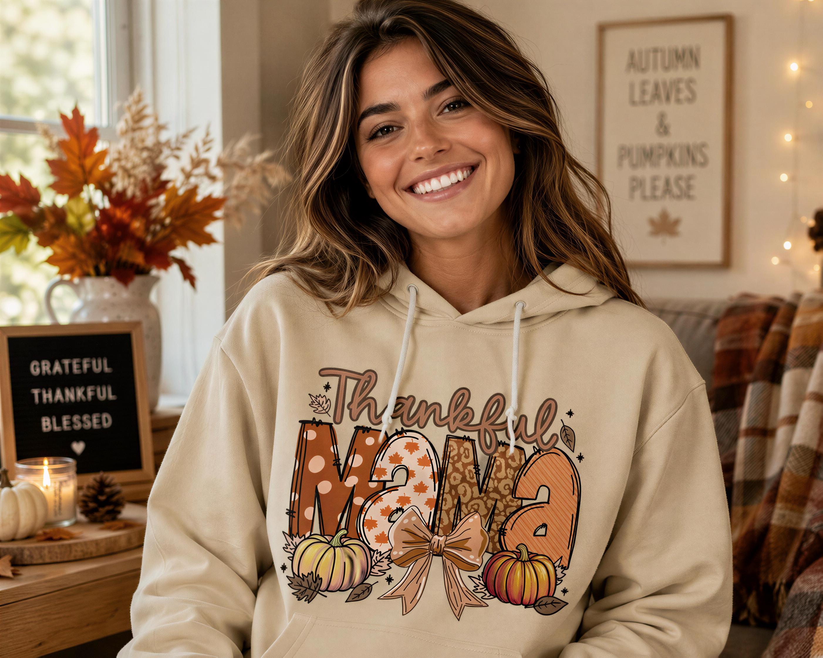 A smiling woman wearing a hooded sweatshirt with a Thanksgiving-themed design.