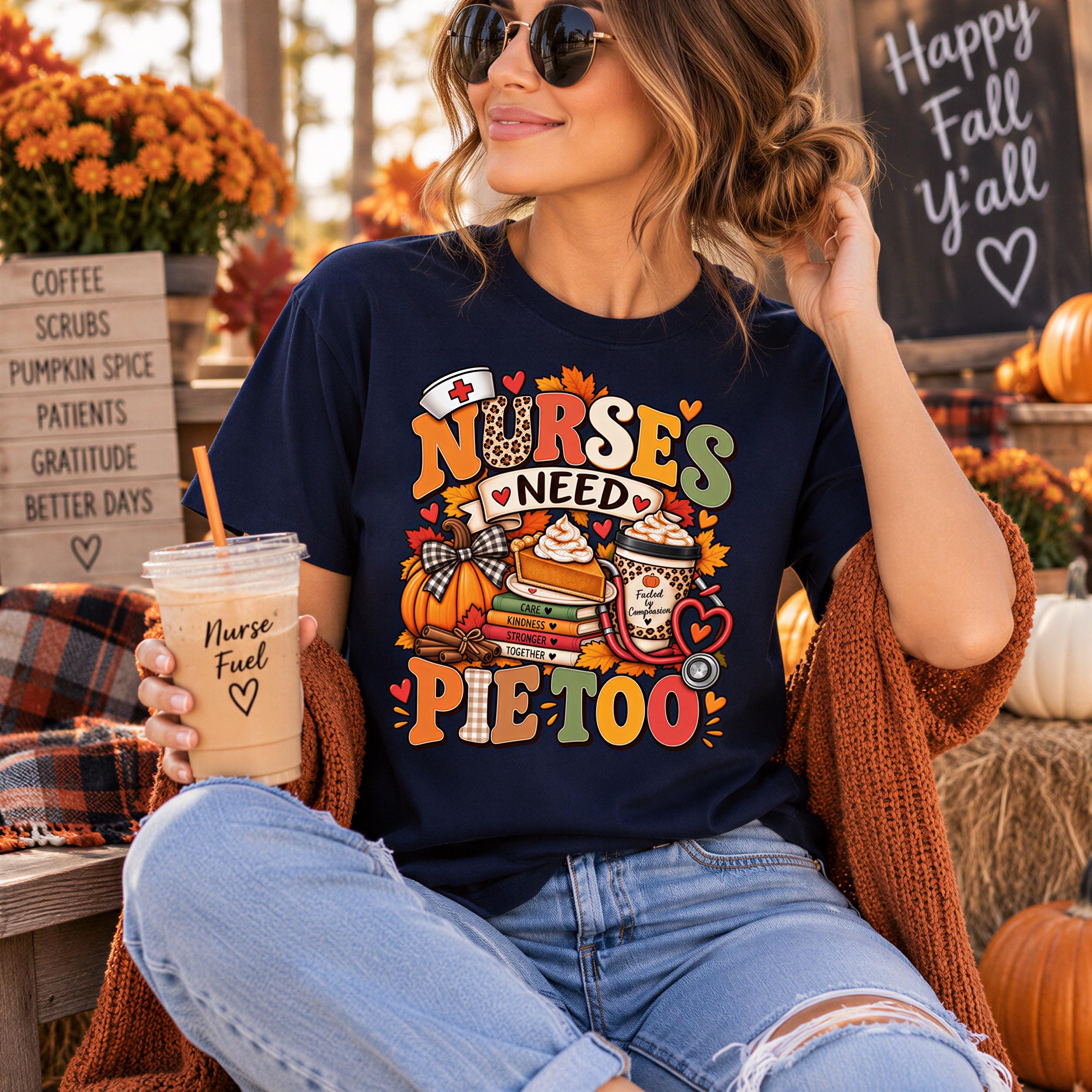 A woman wearing a black t-shirt with a colorful graphic and text, sitting outdoors with a coffee cup in her hand.