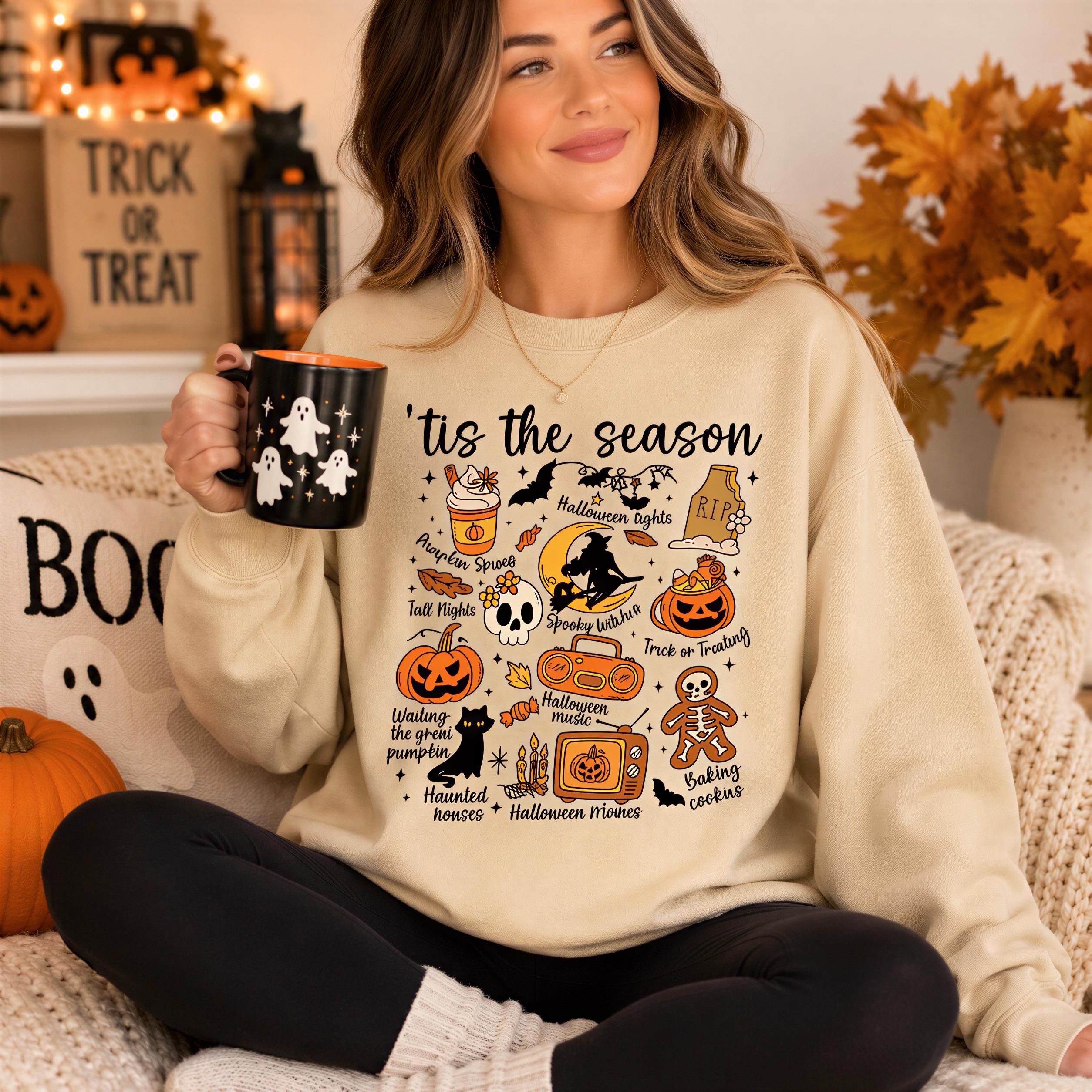 A woman sitting on a couch wearing a sweater with a Halloween-themed design and holding a mug.