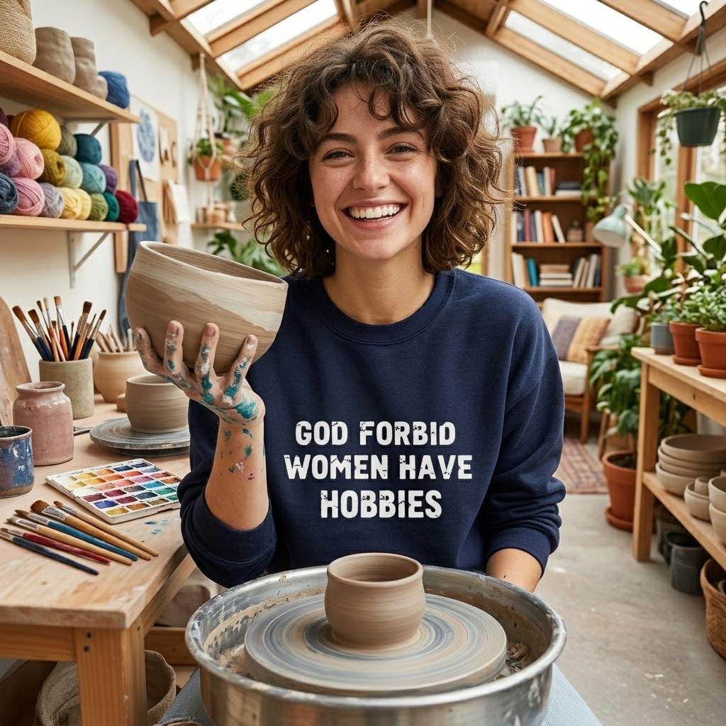 A woman with curly hair is smiling and holding a ceramic bowl in a pottery studio, surrounded by various pottery items and plants.