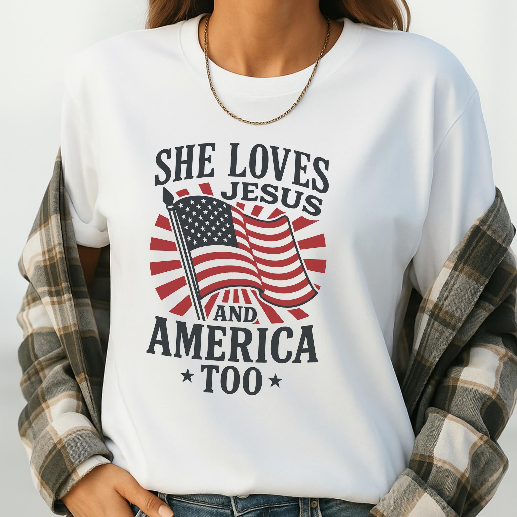 A white t-shirt with a graphic design featuring an American flag and the text "She loves Jesus and America too".