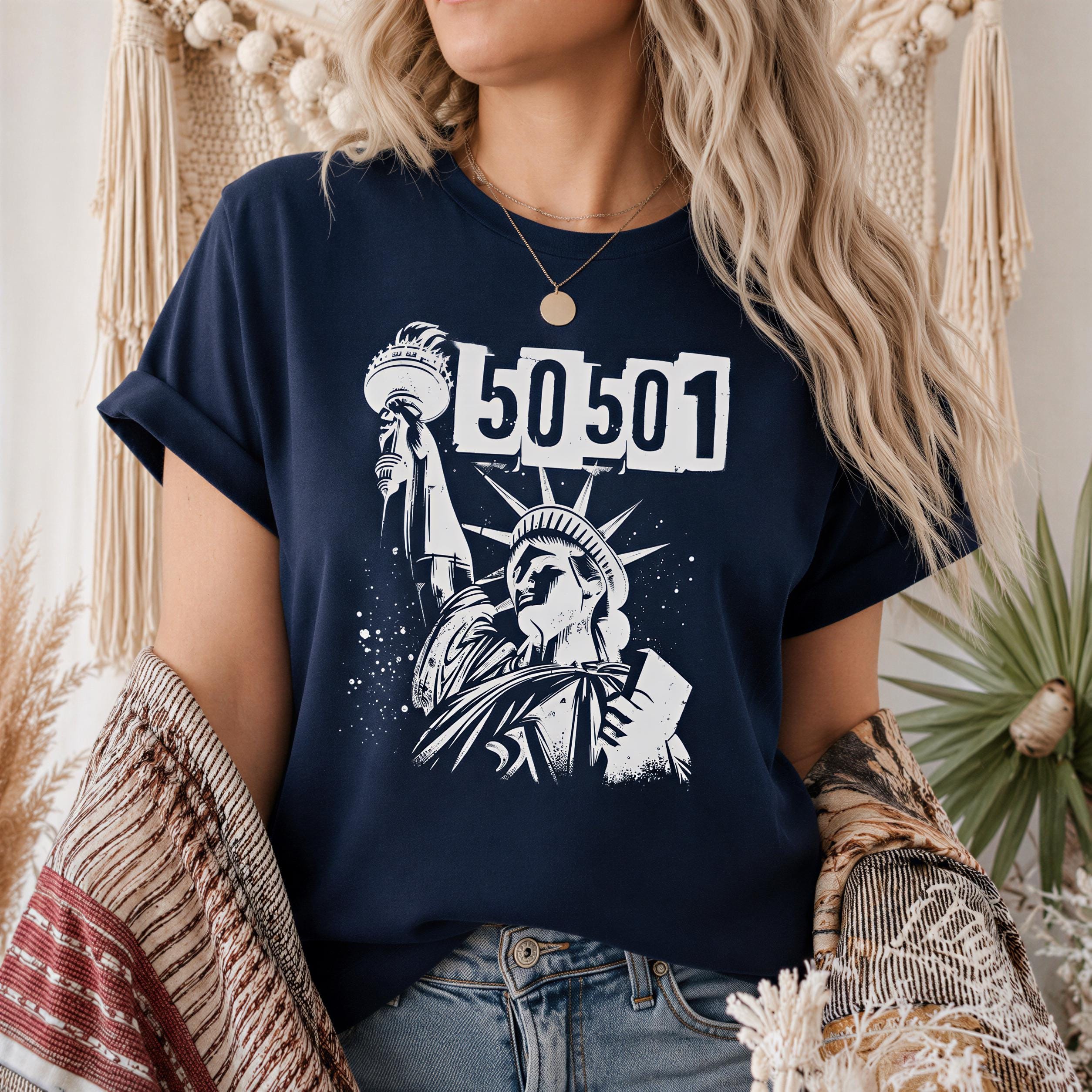 A woman wearing a navy blue t-shirt with a graphic design featuring the Statue of Liberty and the number 50501.