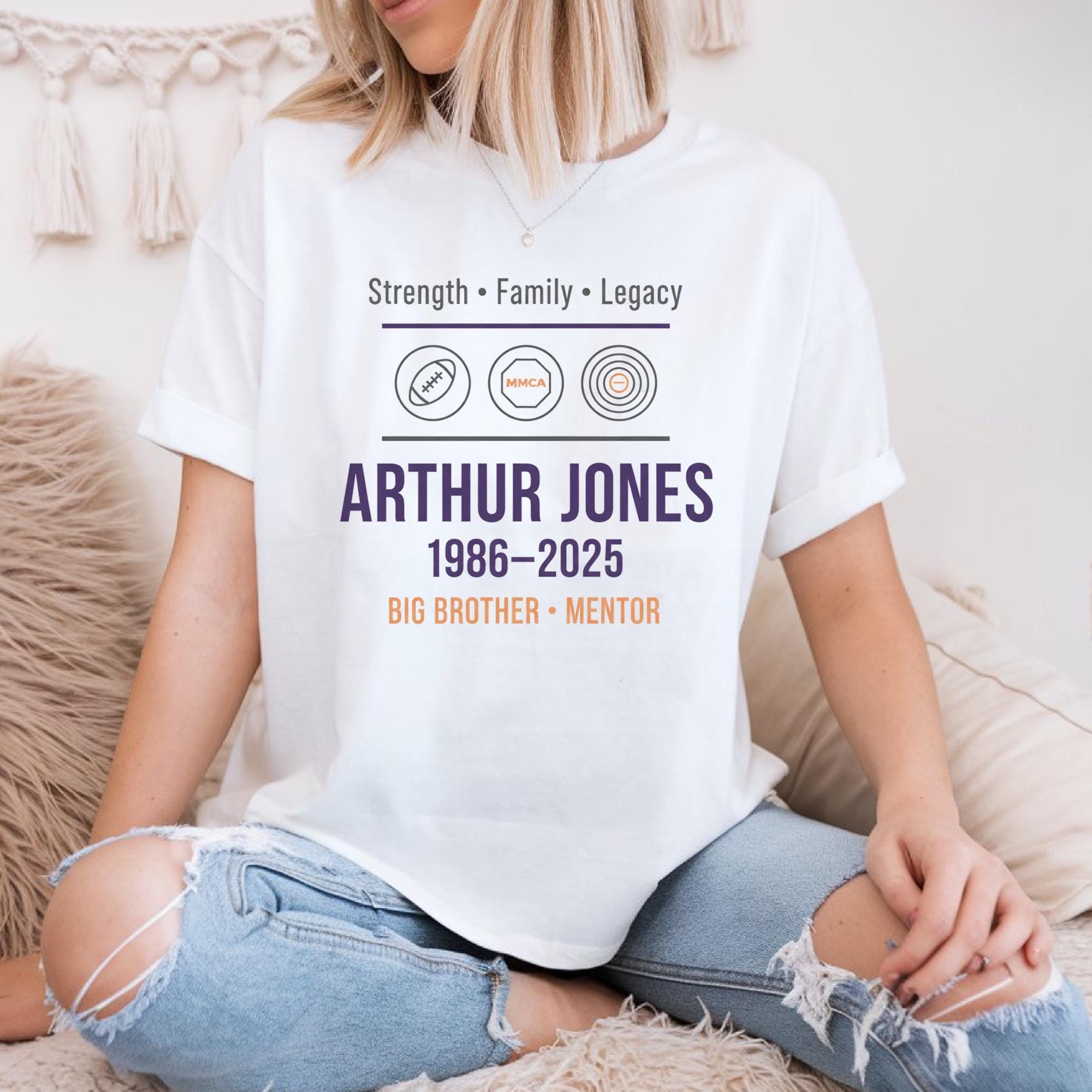 A person wearing a white t-shirt with text and graphics related to Arthur Jones, a former professional baseball player.