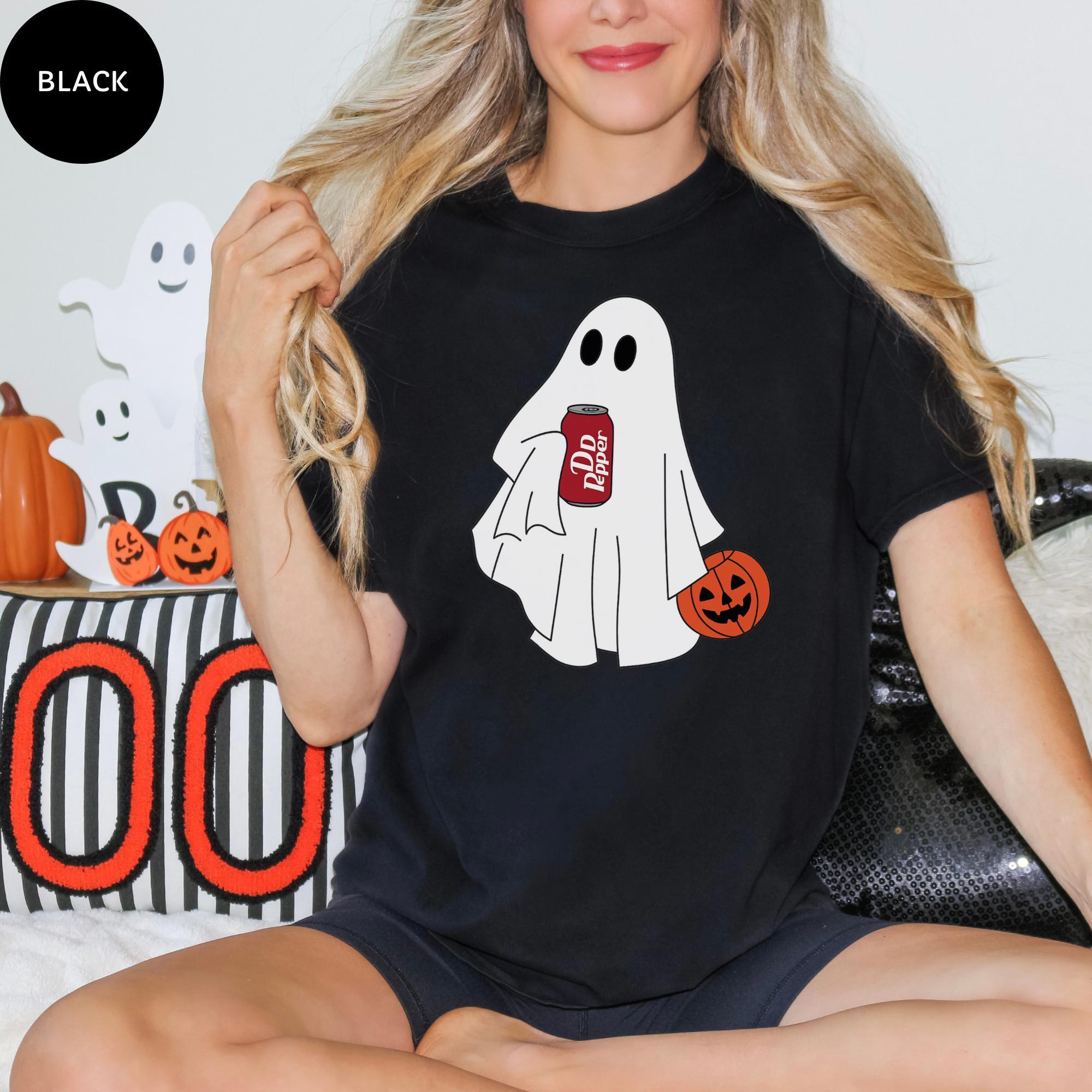A woman wearing a black t-shirt with a graphic of a ghost holding a can of soda.