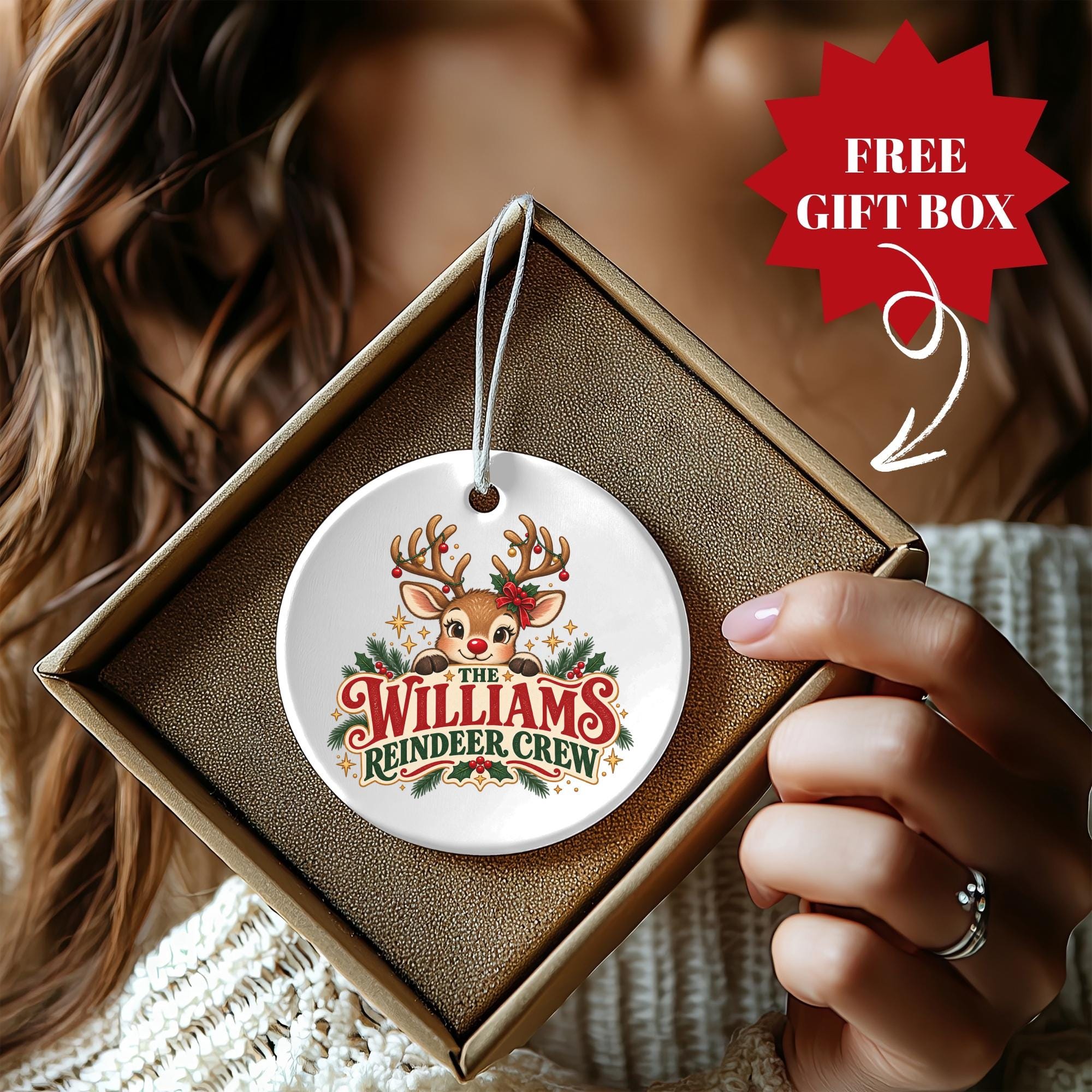 A person is holding a white ceramic ornament with a deer and the text "The Williams Reindeer Crew" on it.