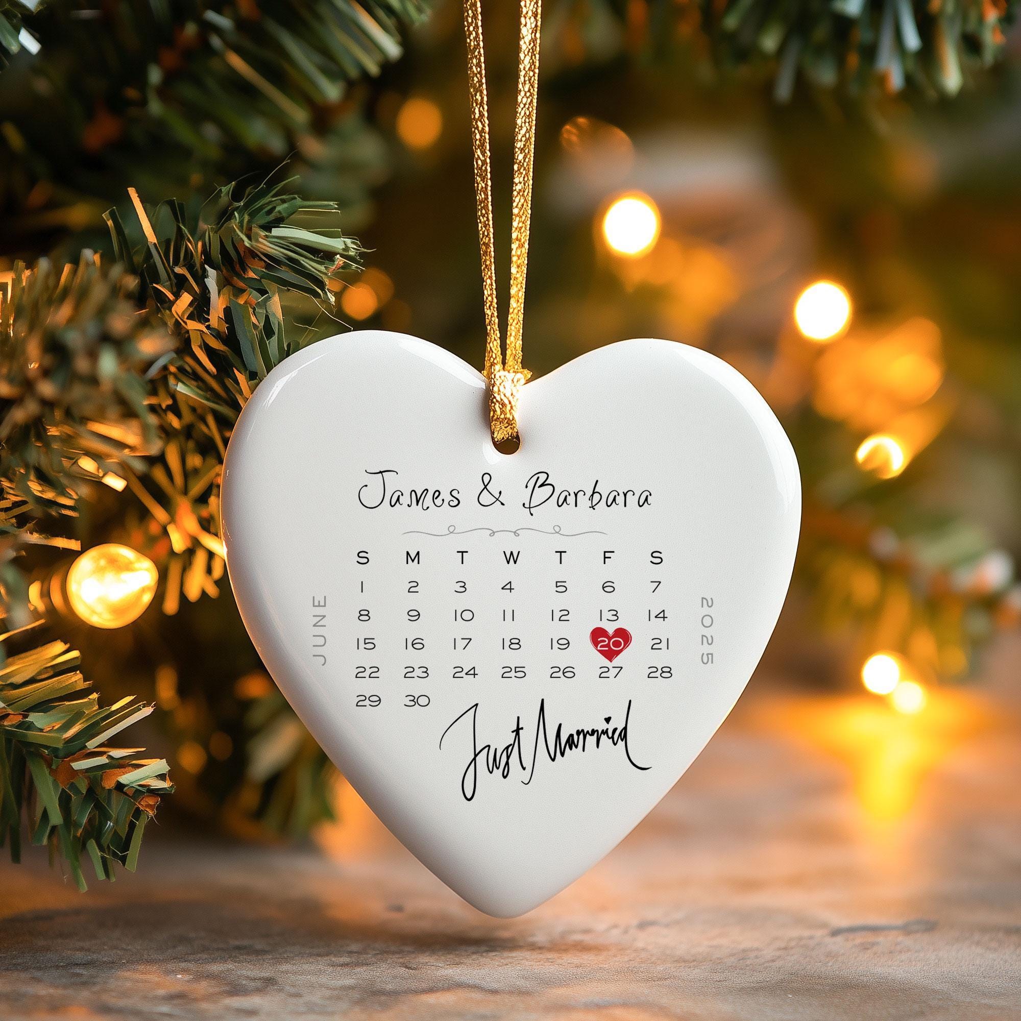 a white heart shaped ornament hanging from a christmas tree