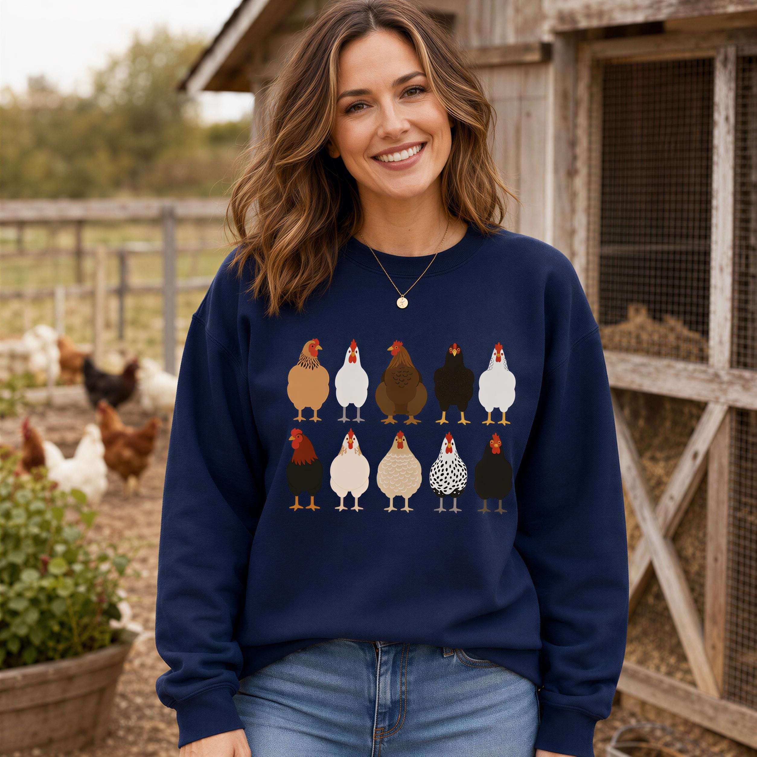 A woman wearing a navy blue sweatshirt with a graphic of a group of chickens standing in a line.