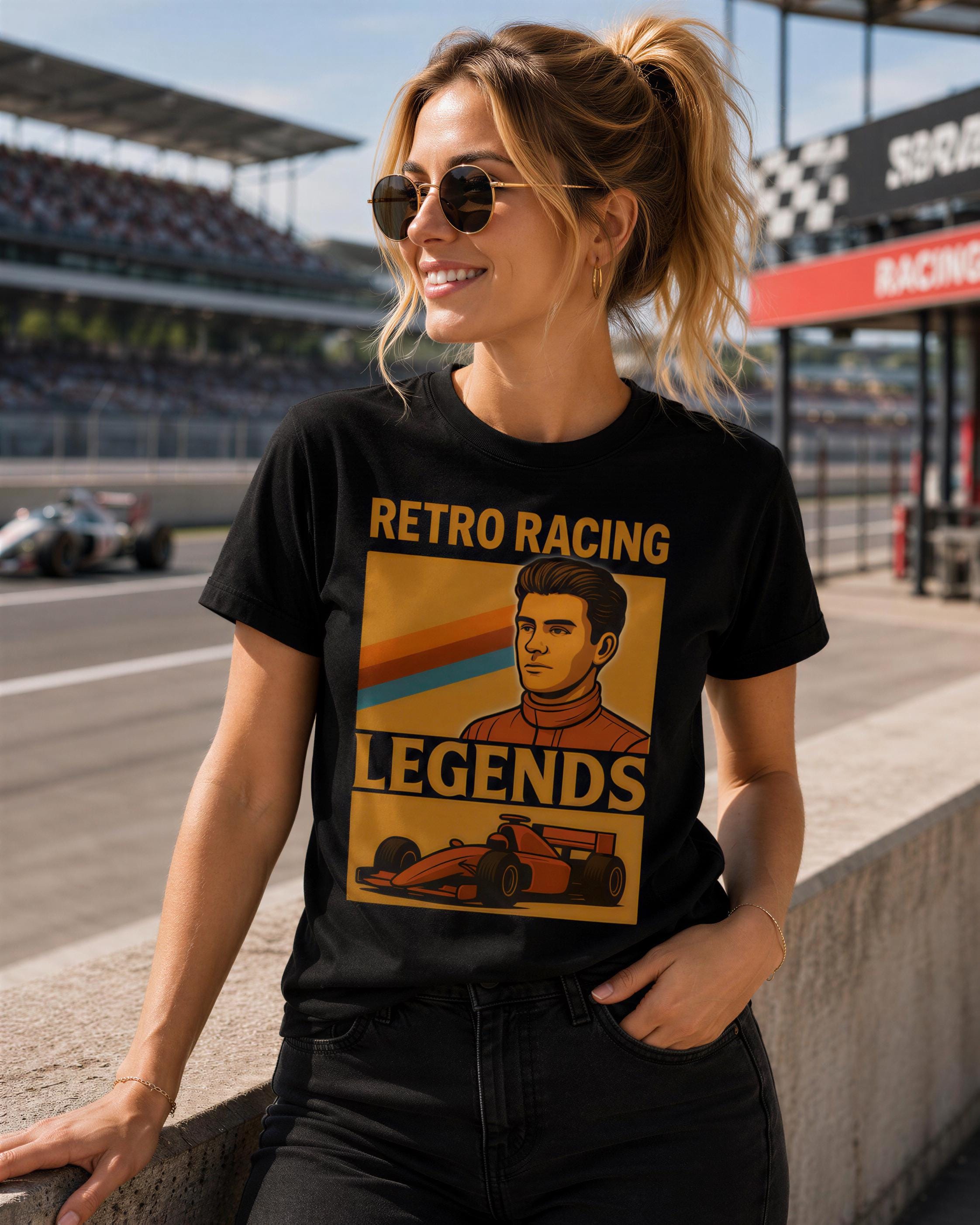 A woman wearing a black t-shirt with a graphic design of a man in a racing suit and the text "Retro Racing Legends" is standing on a race track.