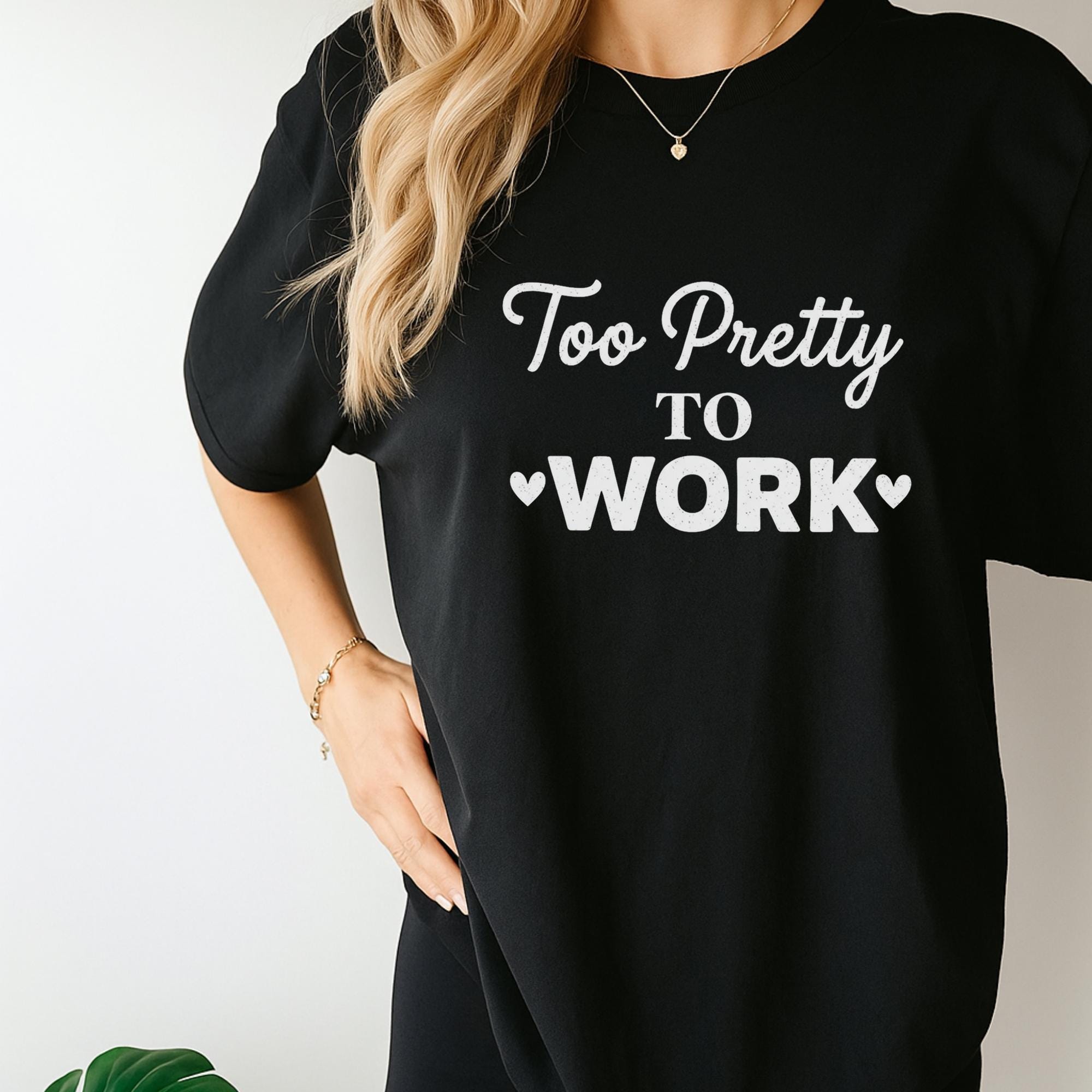 A woman wearing a black t-shirt with the text "Too Pretty to Work" printed on it.