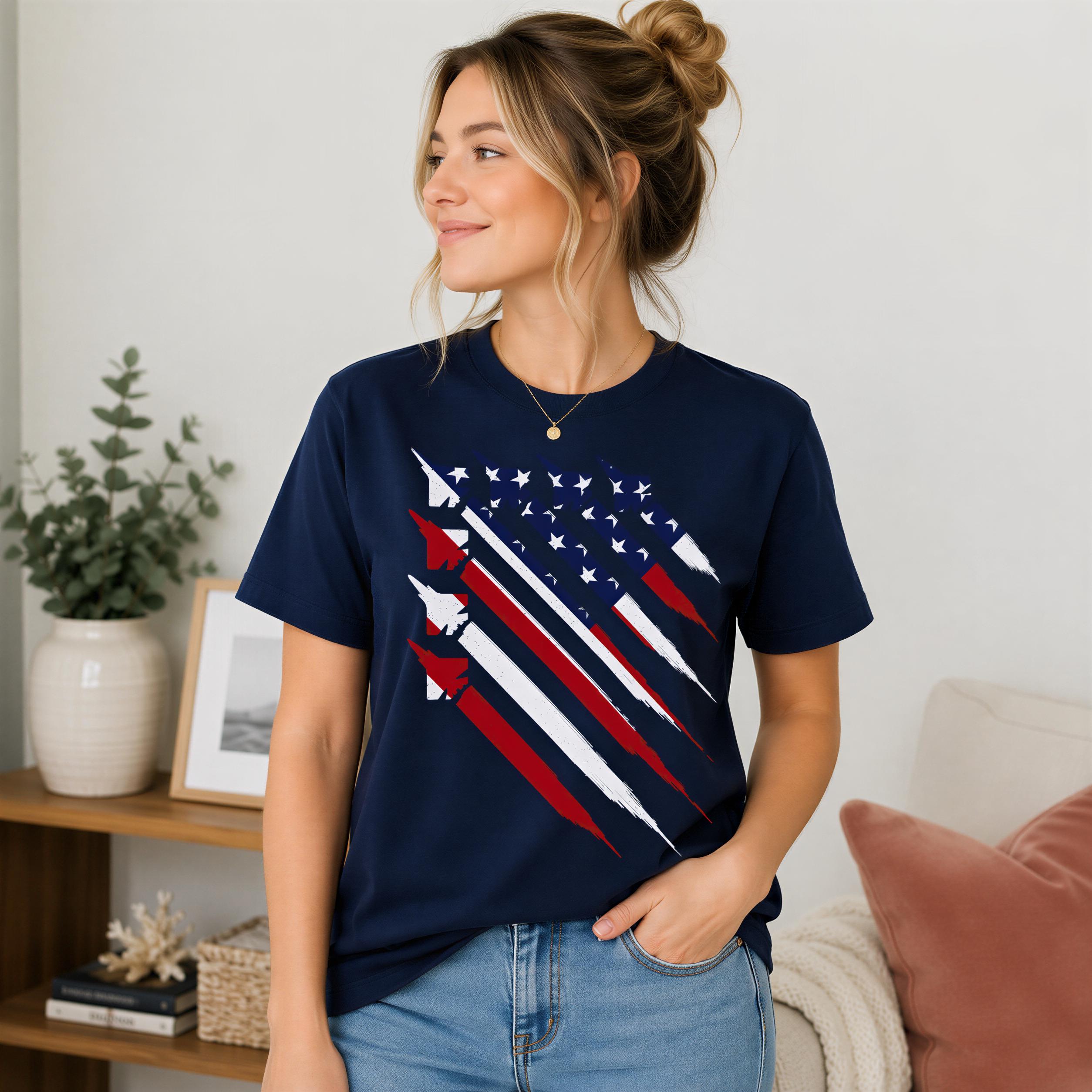 A woman wearing a navy blue t-shirt with a red and white striped design stands in a room with a potted plant and a framed picture on a shelf.