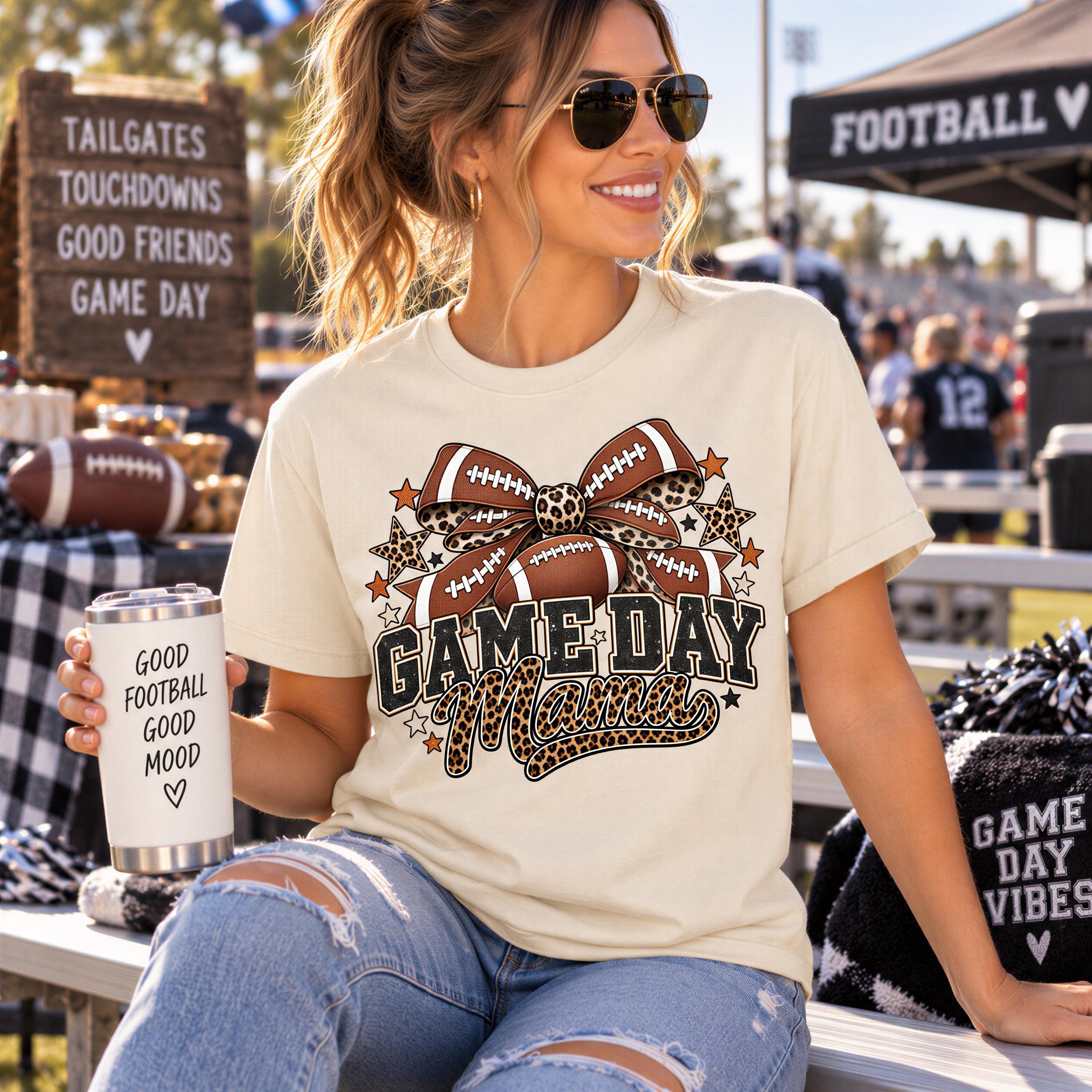 A woman wearing sunglasses and a t-shirt with a football design is sitting on a bench at a sporting event, holding a can with text on it.
