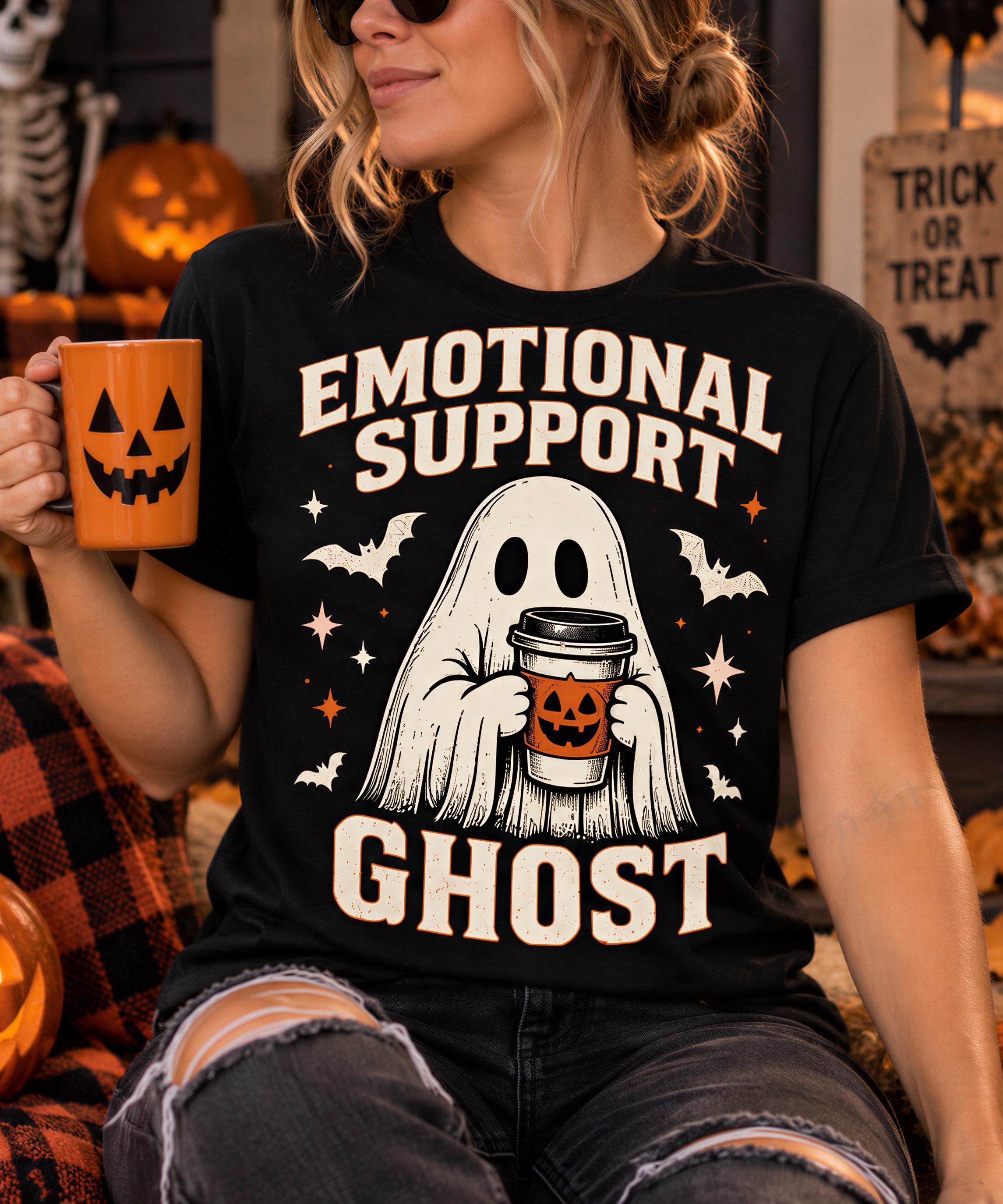 A woman wearing a black t-shirt with a graphic design of a ghost holding a coffee mug, with the text "Emotional Support Ghost" printed on it.