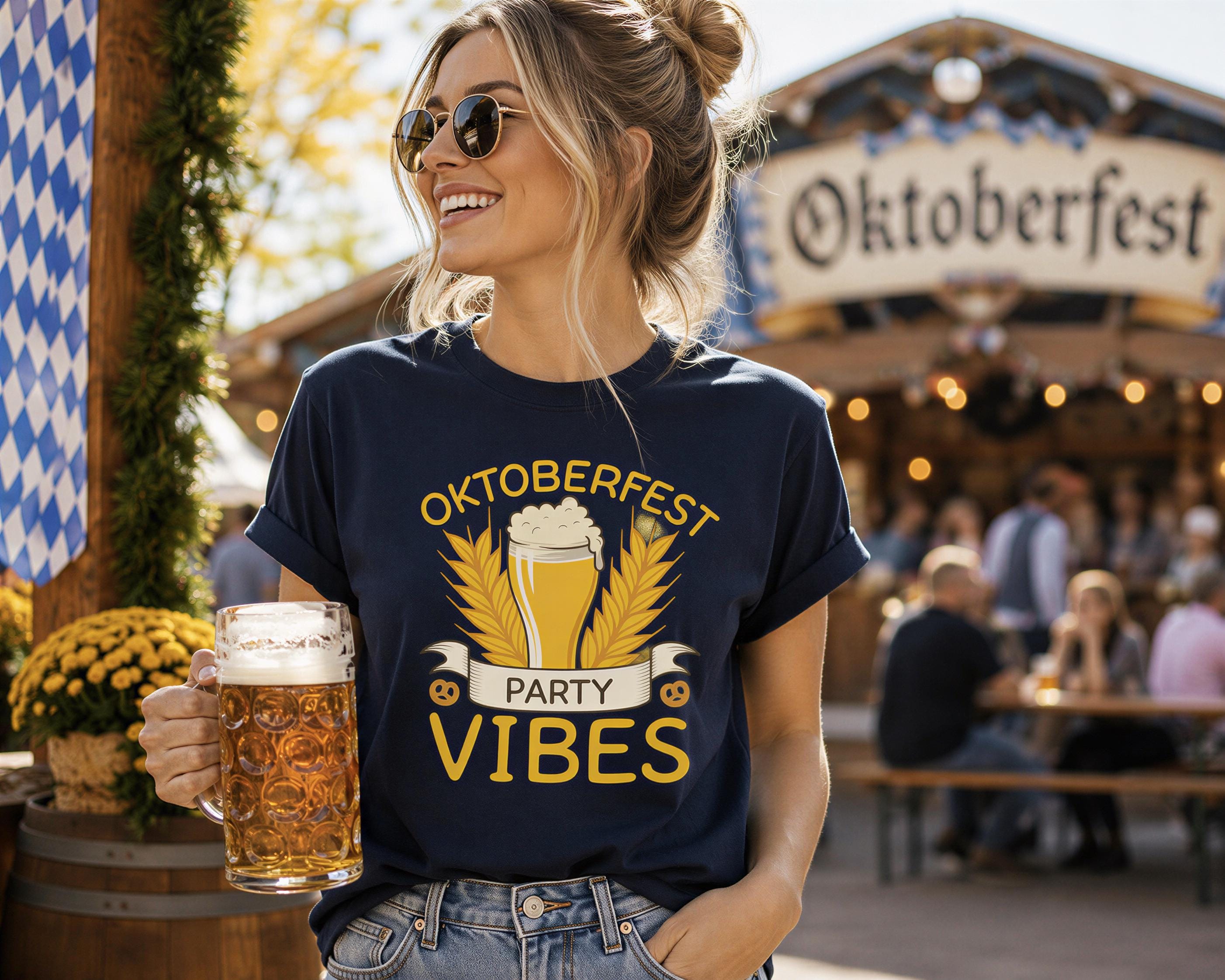 A woman wearing a blue t-shirt with a graphic of a beer mug and the text "Oktoberfest PARTY VIBES" is holding a glass of beer and smiling.