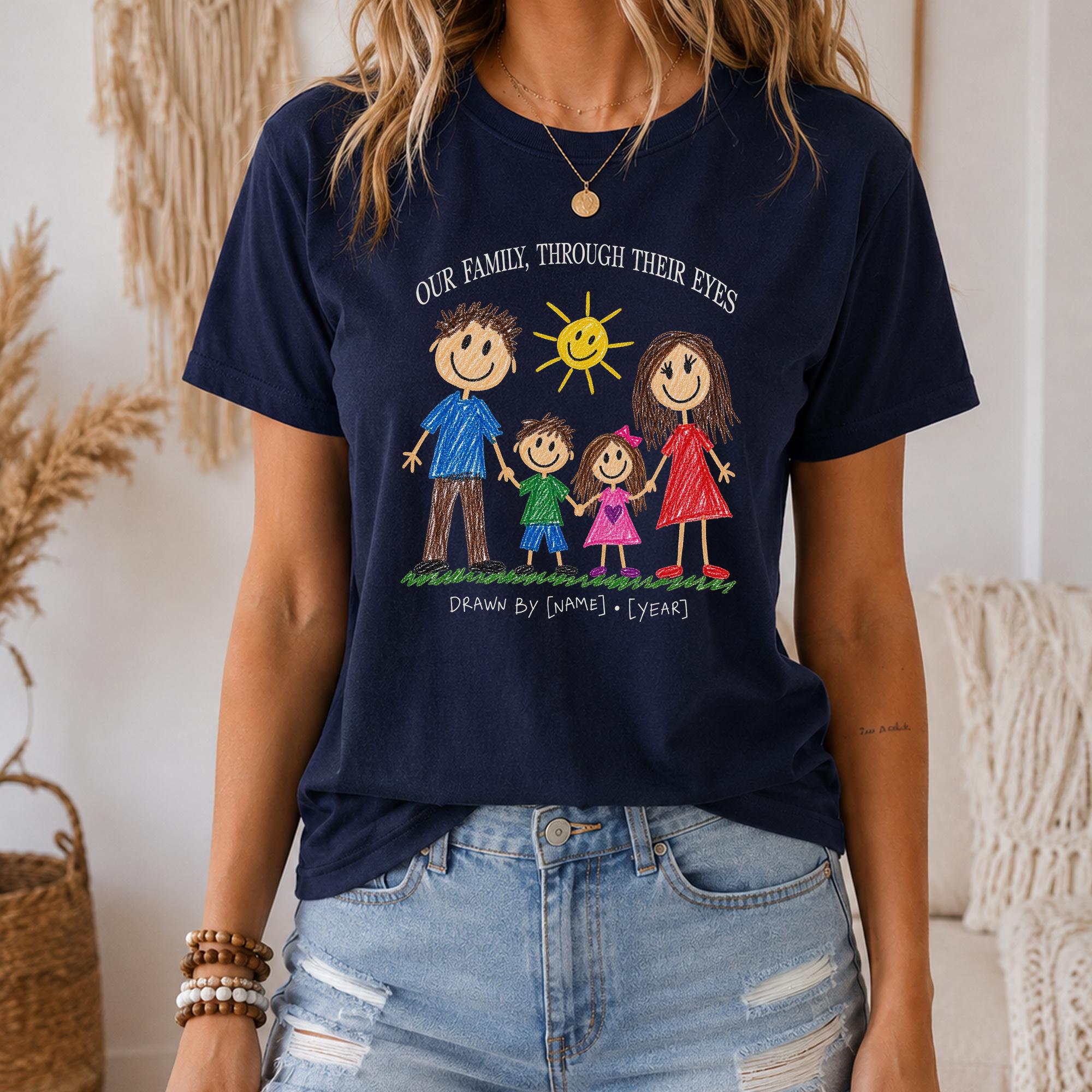 A woman wearing a navy blue t-shirt with a drawing of a family and the text "Our family through their eyes" printed on it.