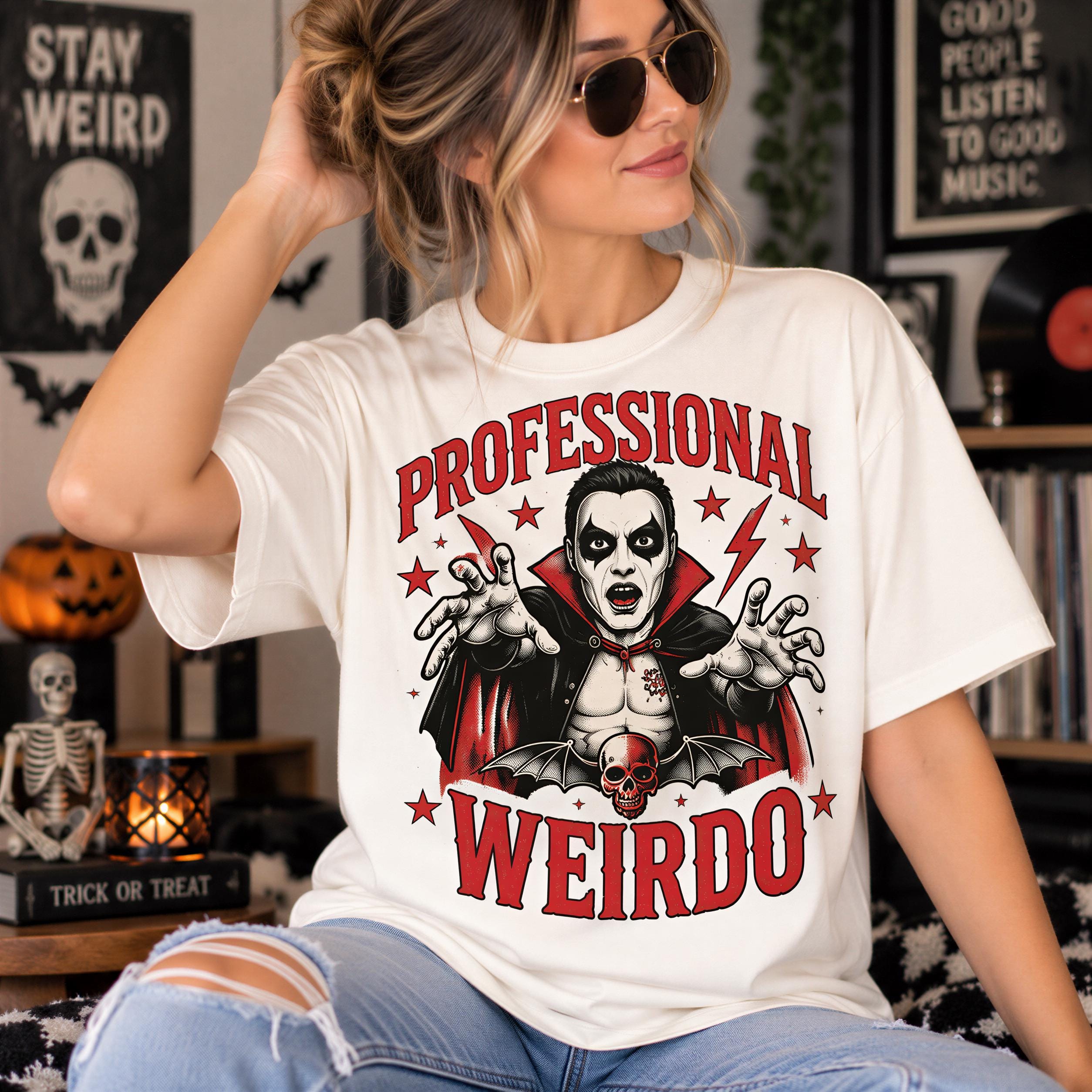 A woman wearing a white t-shirt with a graphic design featuring a vampire character and the text "Professional Weirdo".