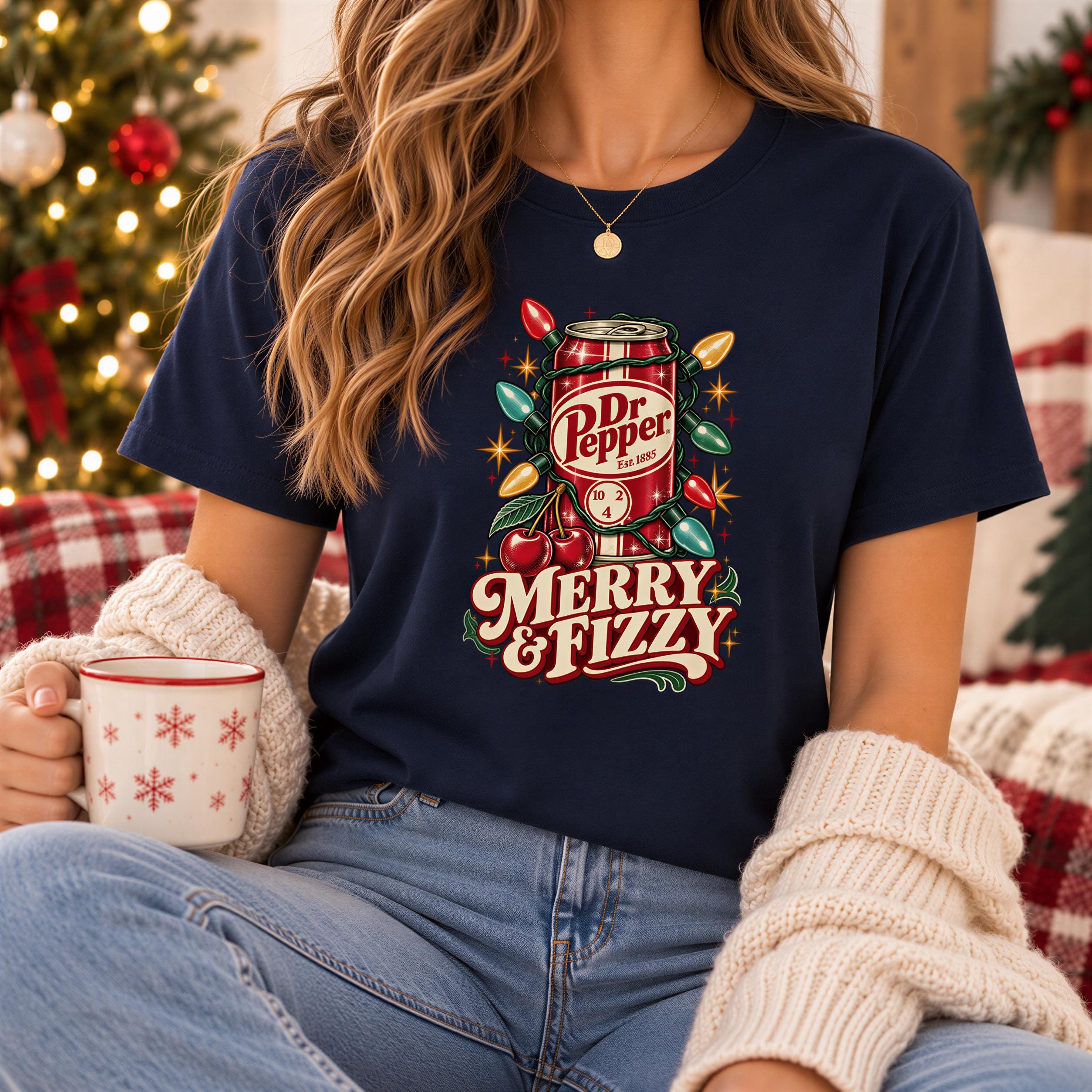 A woman wearing a navy blue t-shirt with a festive design and holding a mug with snowflake patterns.