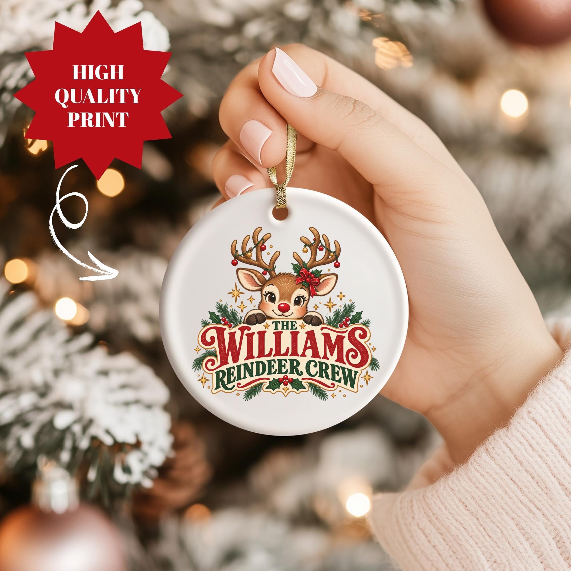 A hand holding a white ornament with a reindeer and the text "The Williams Reindeer Crew" printed on it.