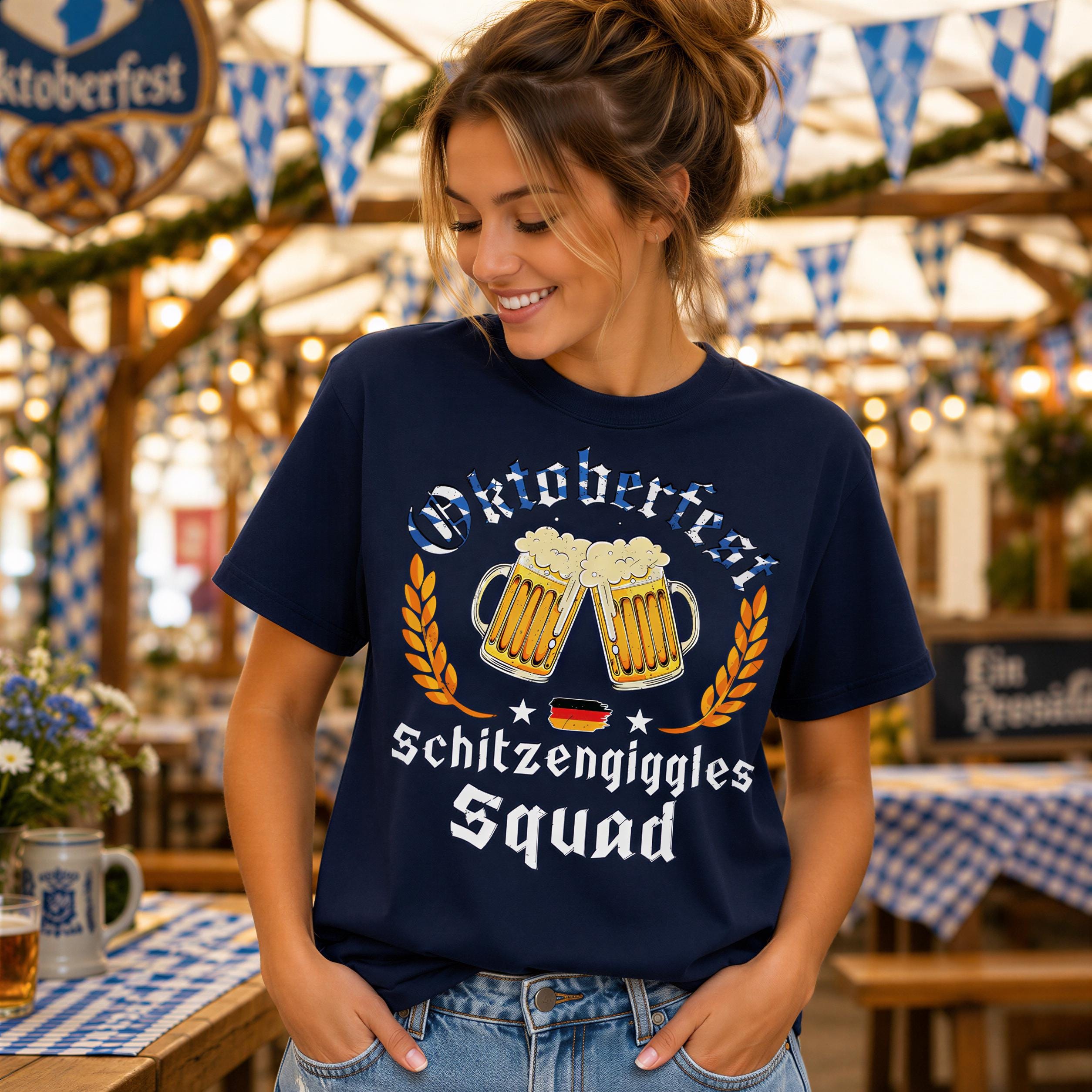 A woman wearing a navy blue t-shirt with a graphic design of beer mugs and the text "Oktoberfest Schitzgiggles Squad" is smiling at the camera.