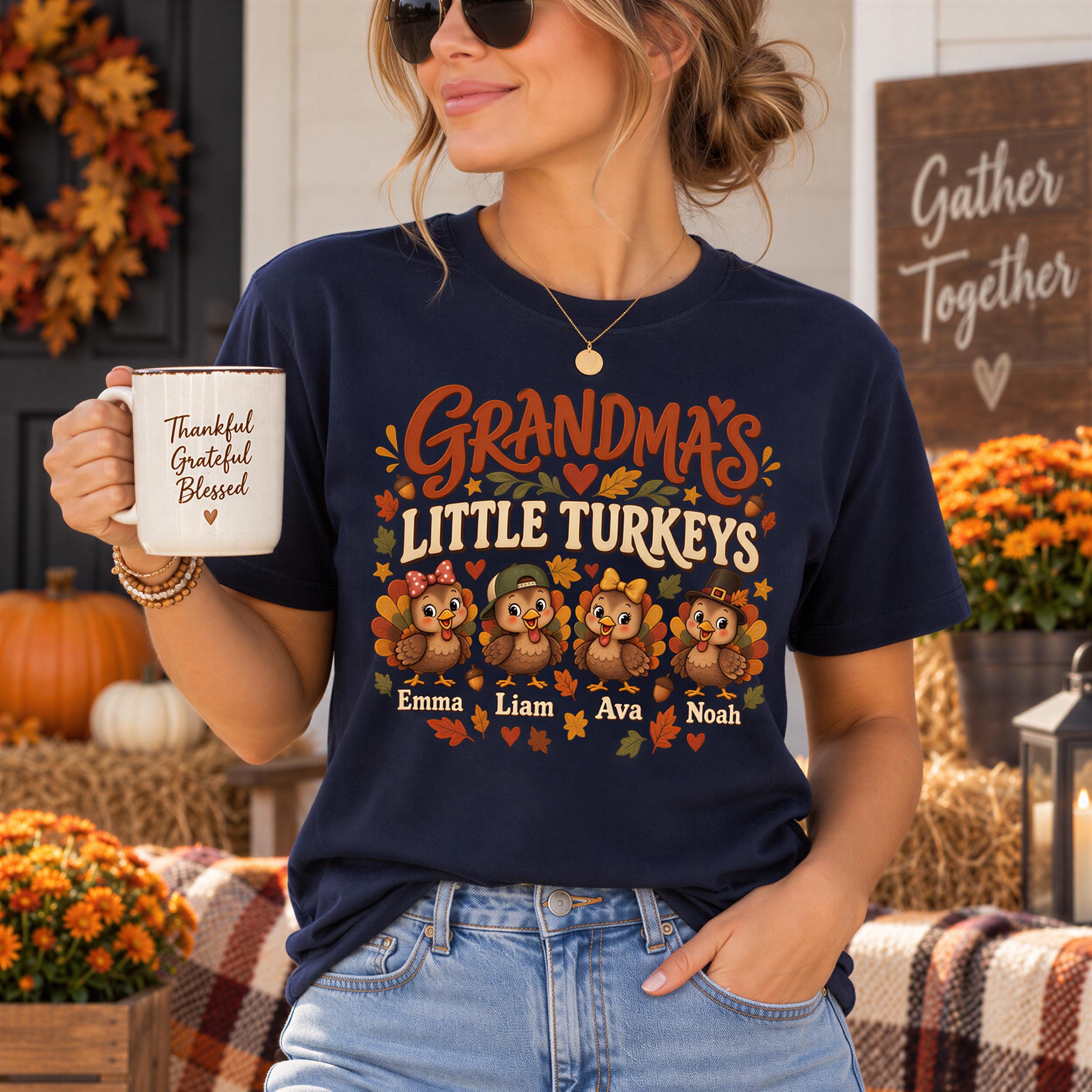 A woman wearing a blue t-shirt with a graphic design of turkeys and the text "Grandma's Little Turkeys" is holding a coffee mug and standing in front of a fall-themed background.