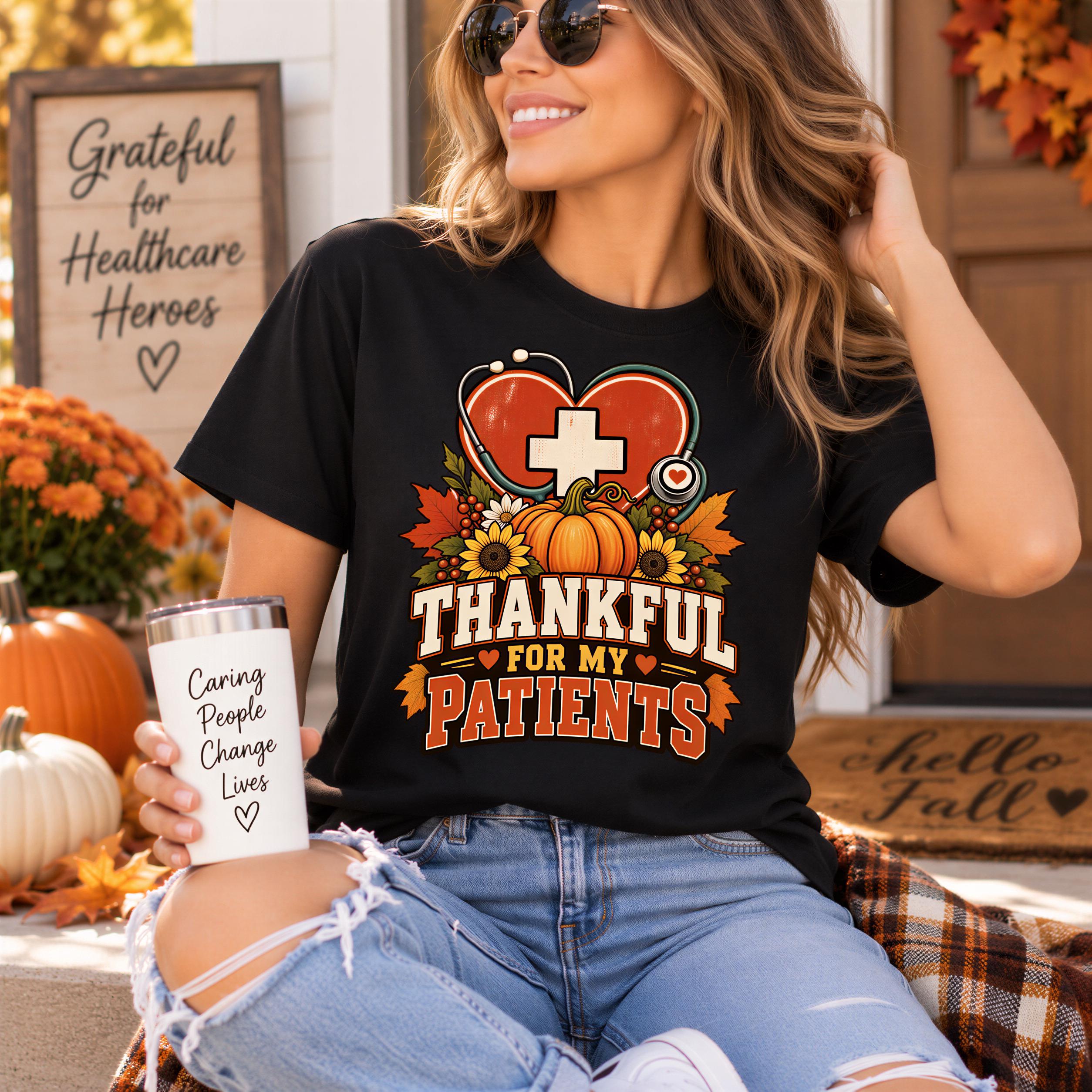 A woman wearing a black t-shirt with a graphic design and holding a white cup with text on it, sitting on a porch with fall decorations in the background.