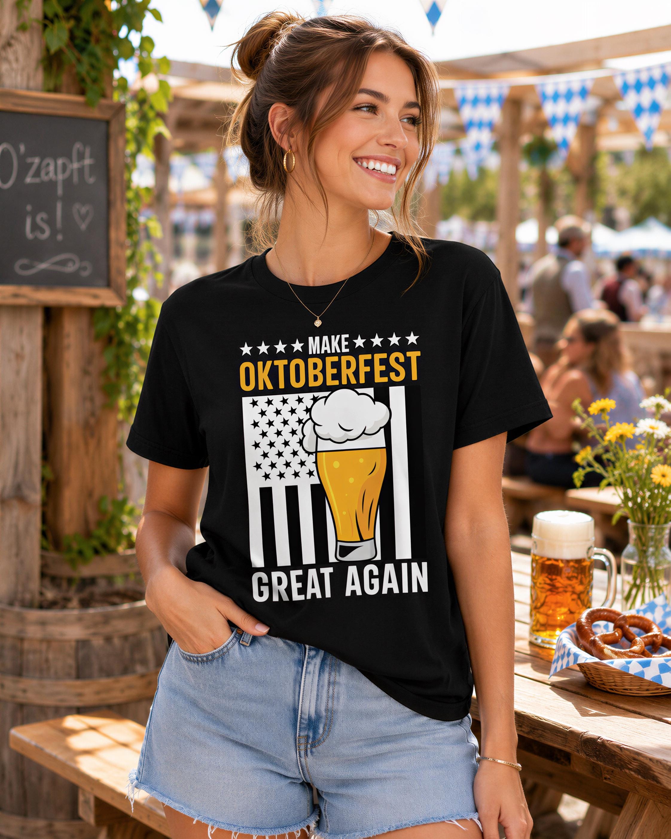 A woman wearing a black t-shirt with a graphic design of a beer mug and the text "Make Oktoberfest Great Again" is smiling and posing in front of a wooden structure with a chalkboard sign.