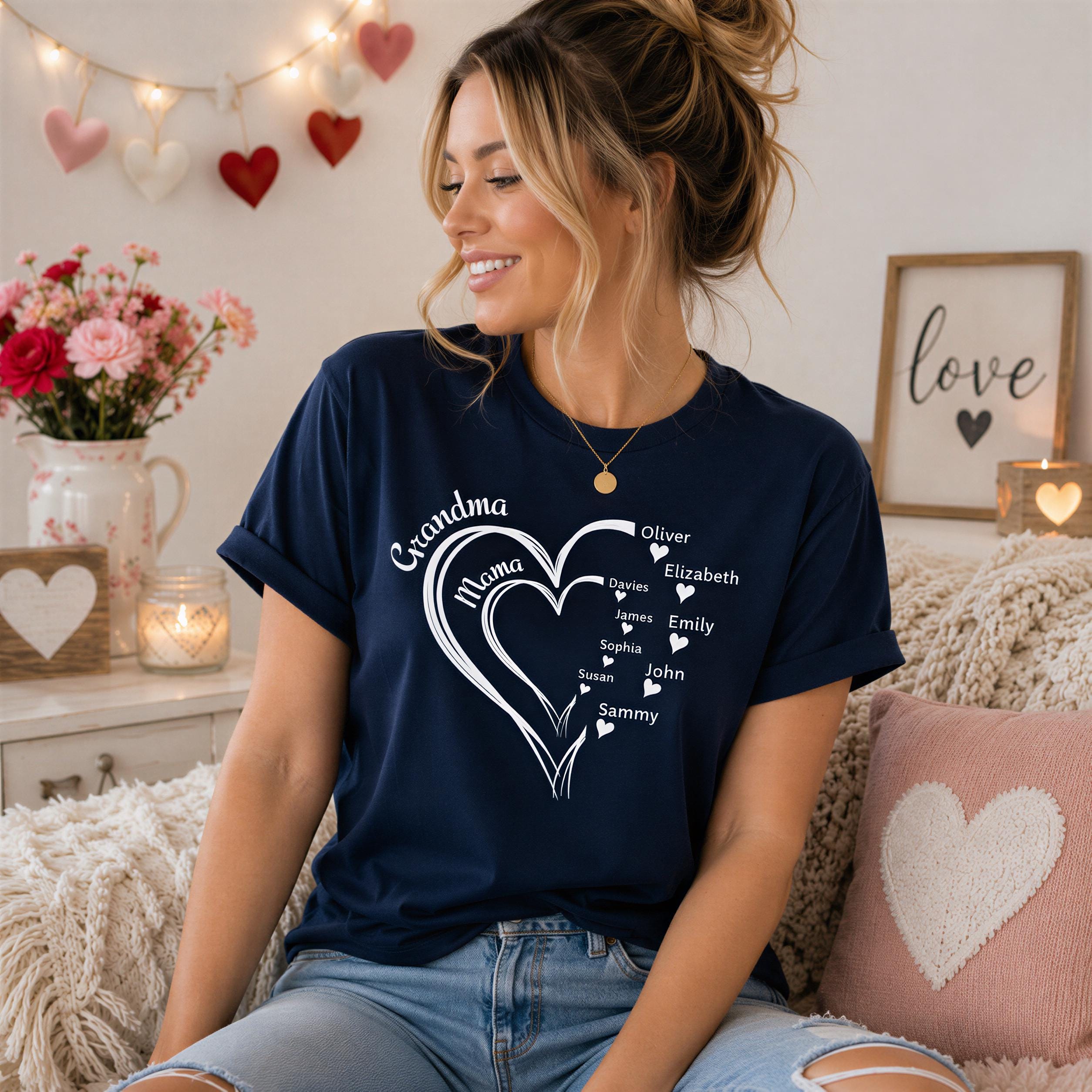 A smiling woman wearing a blue t-shirt with a heart design and text, sitting on a couch in a cozy room with a floral arrangement and heart-shaped decorations.