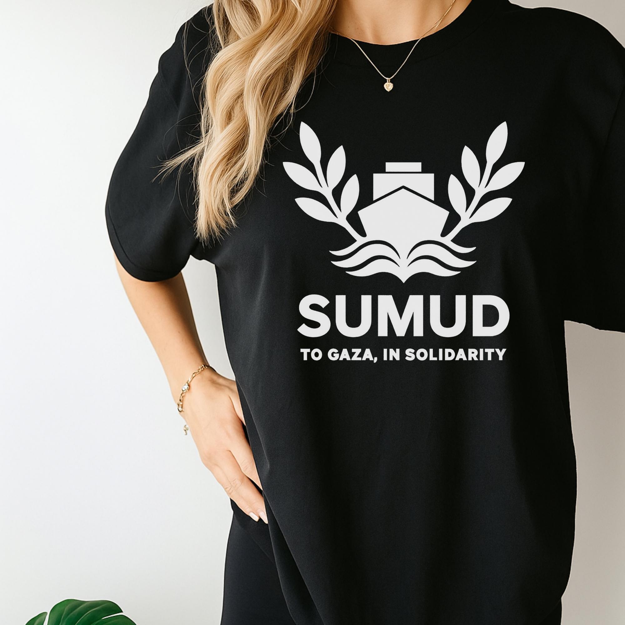 A woman wearing a black t-shirt with a white graphic design and text on it.