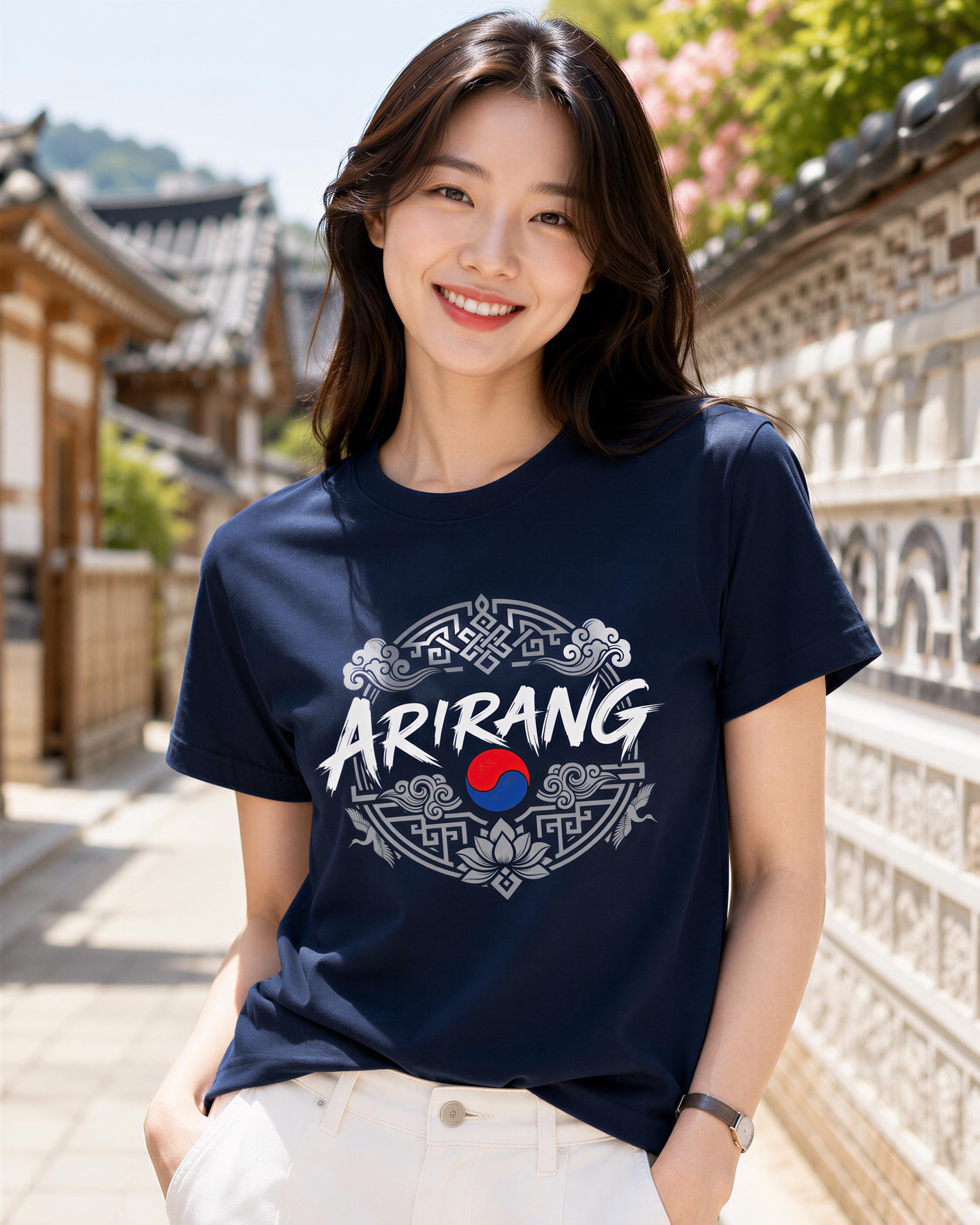 A young woman wearing a navy blue t-shirt with the word "ARIRANG" printed on it, standing in front of a traditional Korean building.