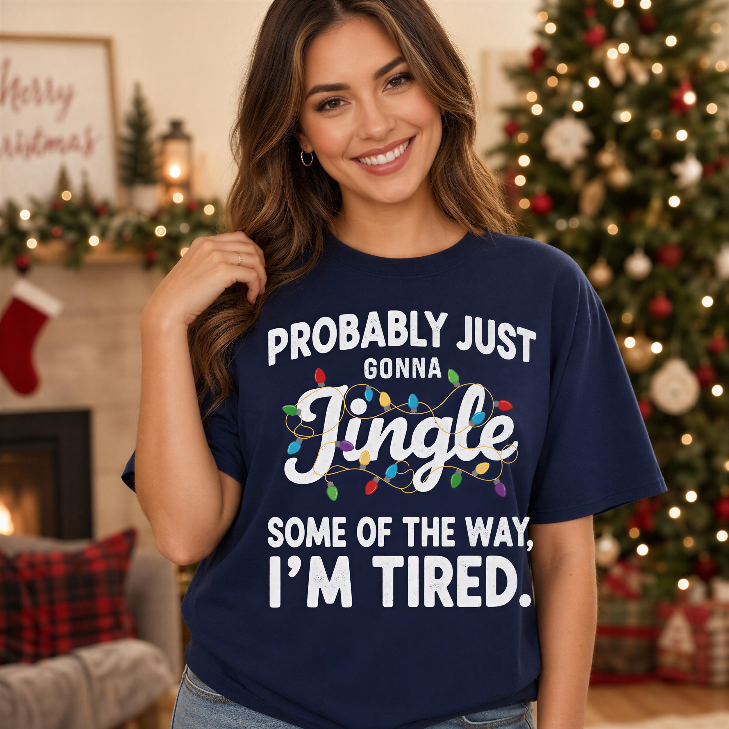 A woman wearing a navy blue t-shirt with a humorous text printed on it, smiling and posing in front of a Christmas tree.