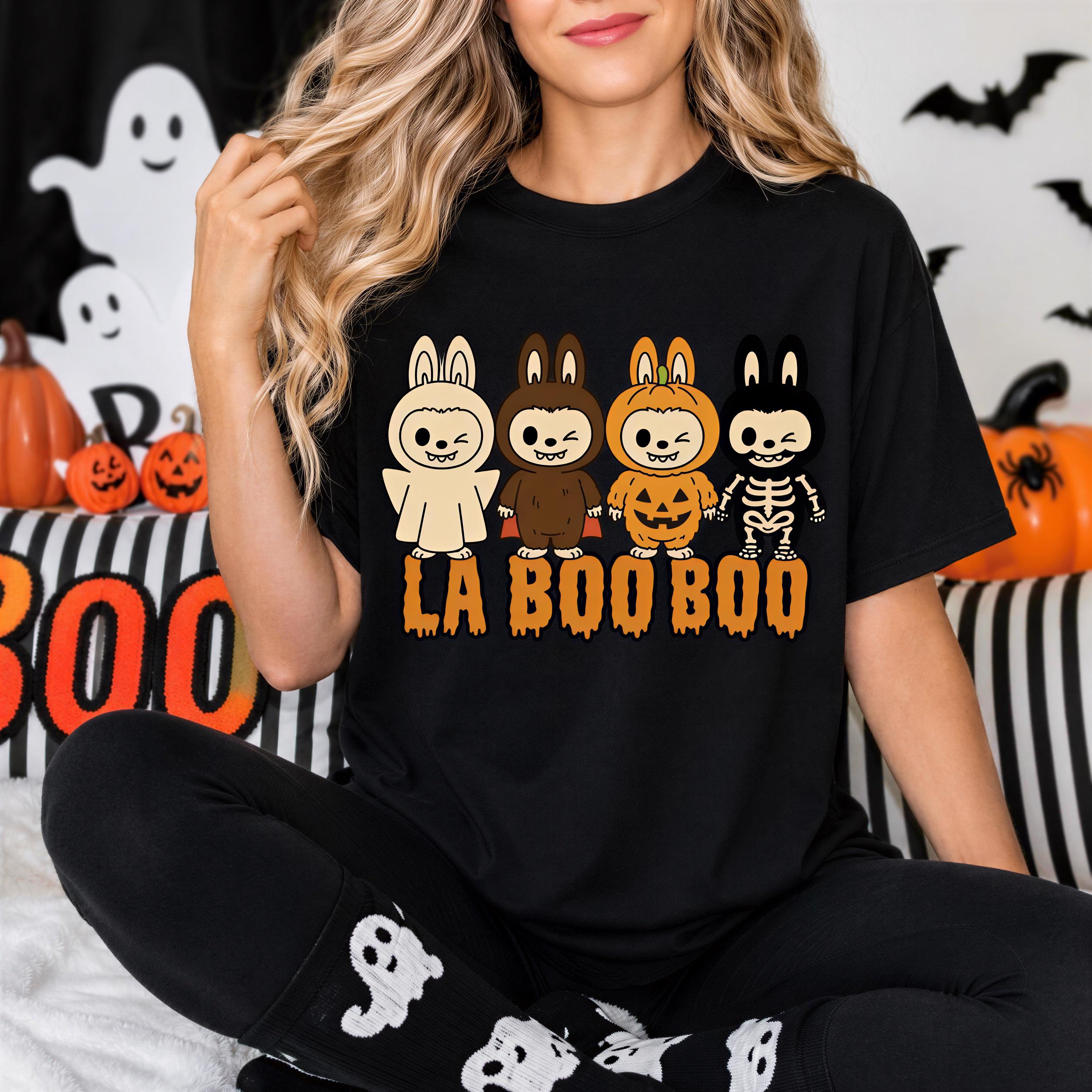 A woman wearing a black t-shirt with a graphic design of five cartoon bunny characters, each with a unique costume, and the text "LA BOO BO" printed on it.