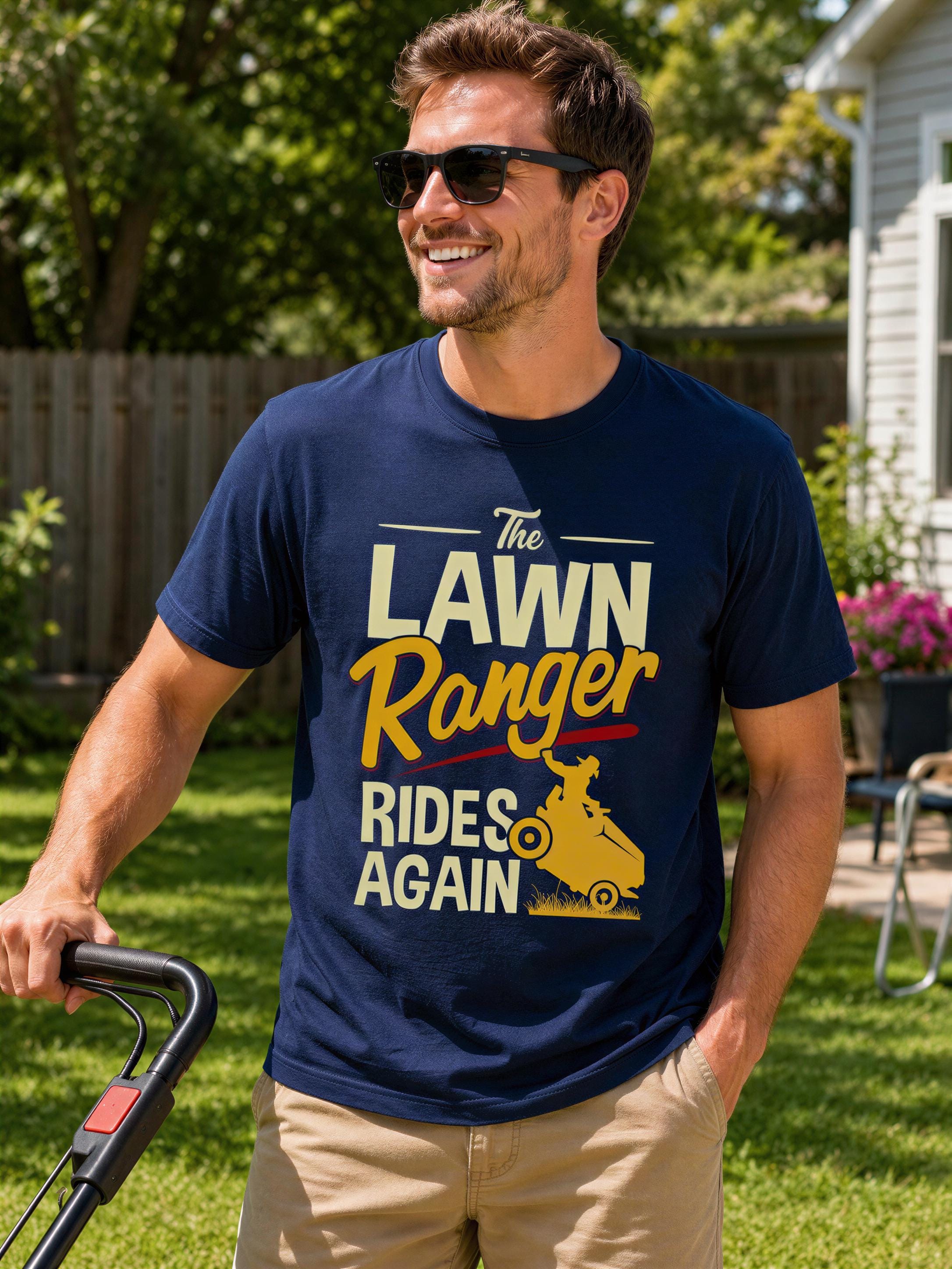 A man wearing a blue t-shirt with a graphic design and text, smiling and standing in a grassy yard.