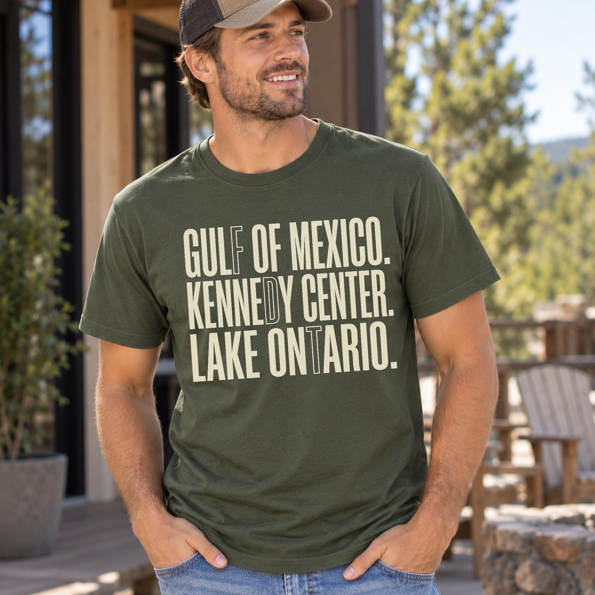 A man wearing a green t-shirt with text printed on it, standing outdoors in front of a building.