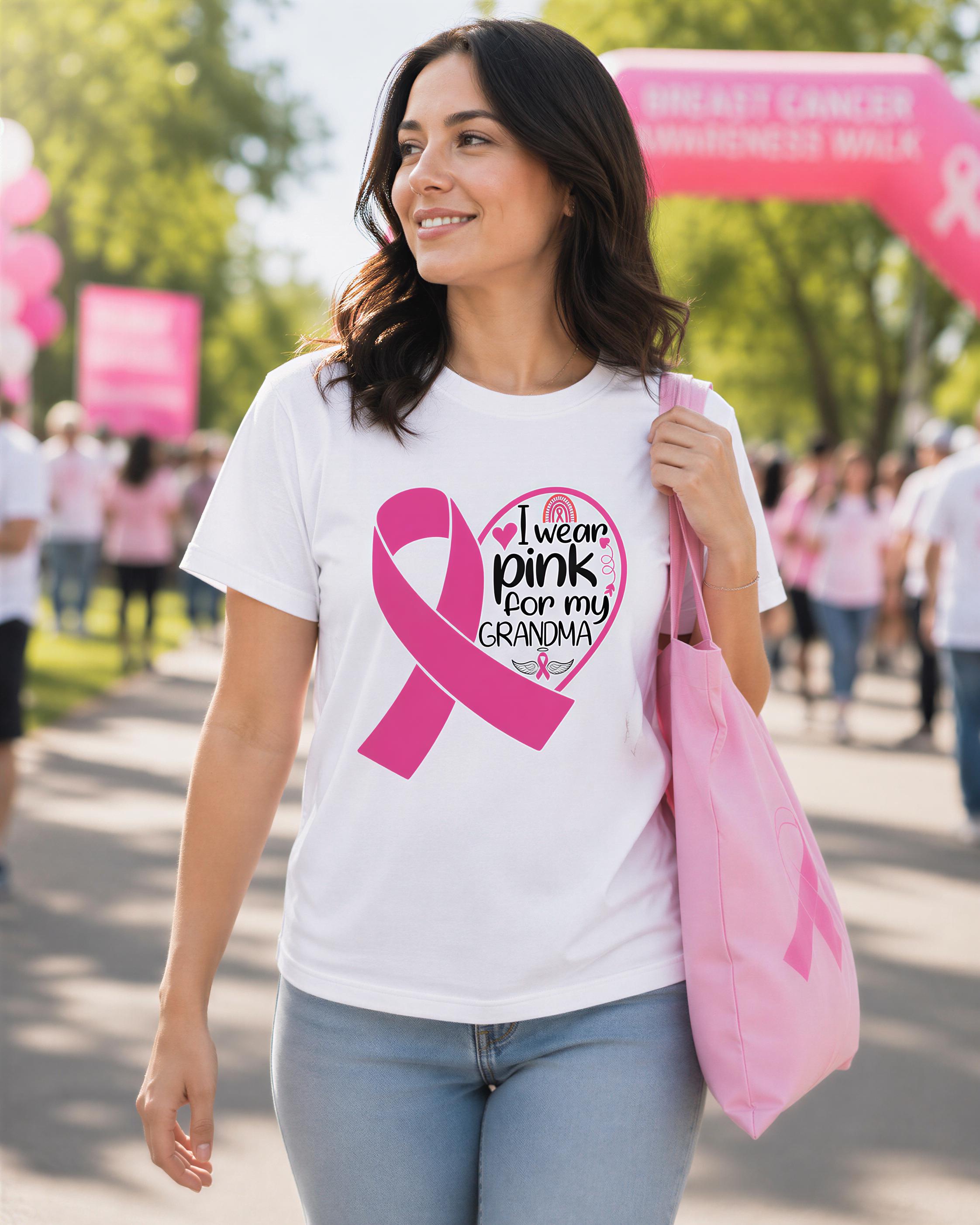 A woman wearing a white t-shirt with a pink ribbon design and text, walking on a path with a pink bag.