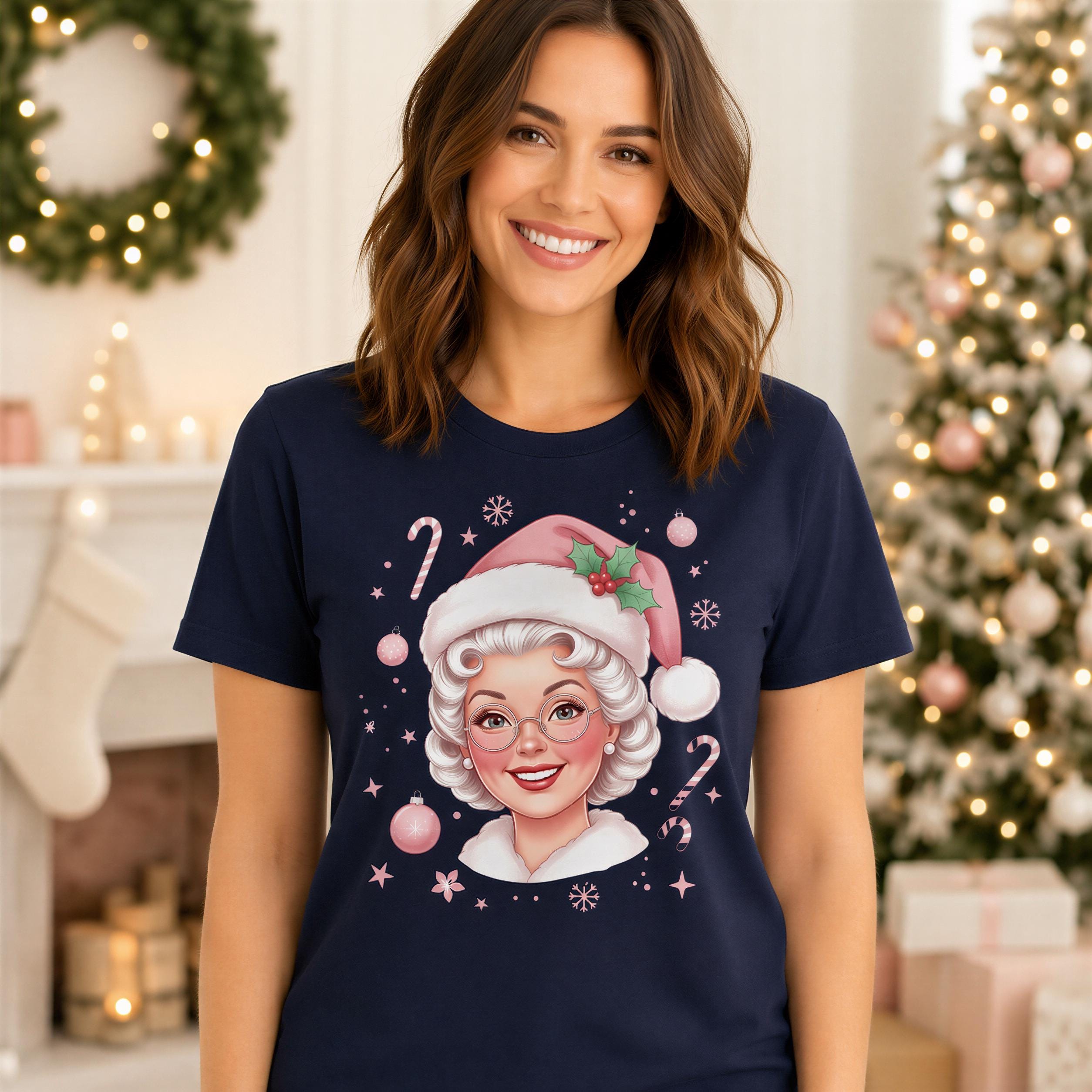 A woman wearing a navy blue t-shirt with a graphic of a smiling woman wearing a Santa hat and surrounded by Christmas decorations.