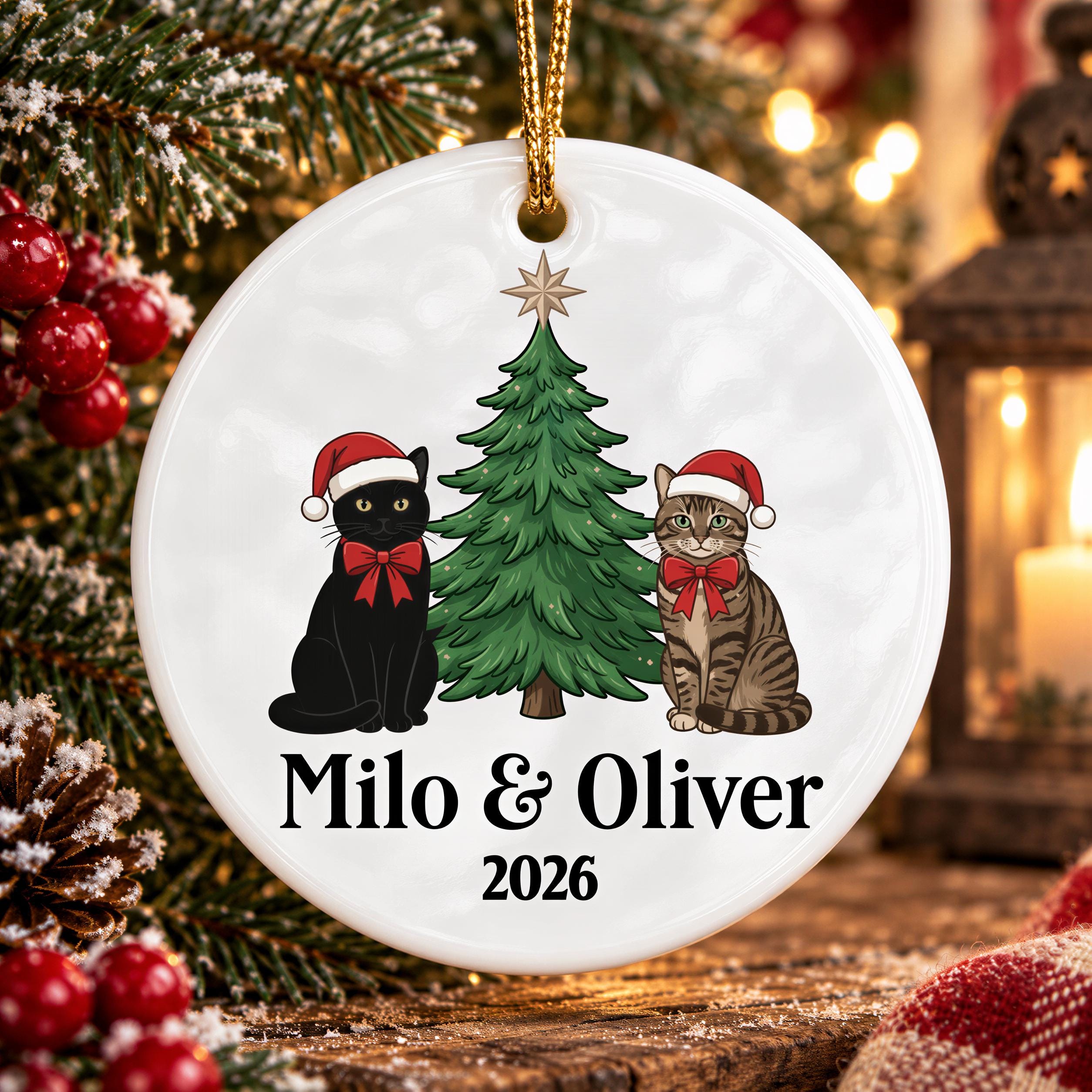 A white Christmas ornament with a tree and two cats wearing Santa hats, with the text "Milo & Oliver" and "2026" printed on it.