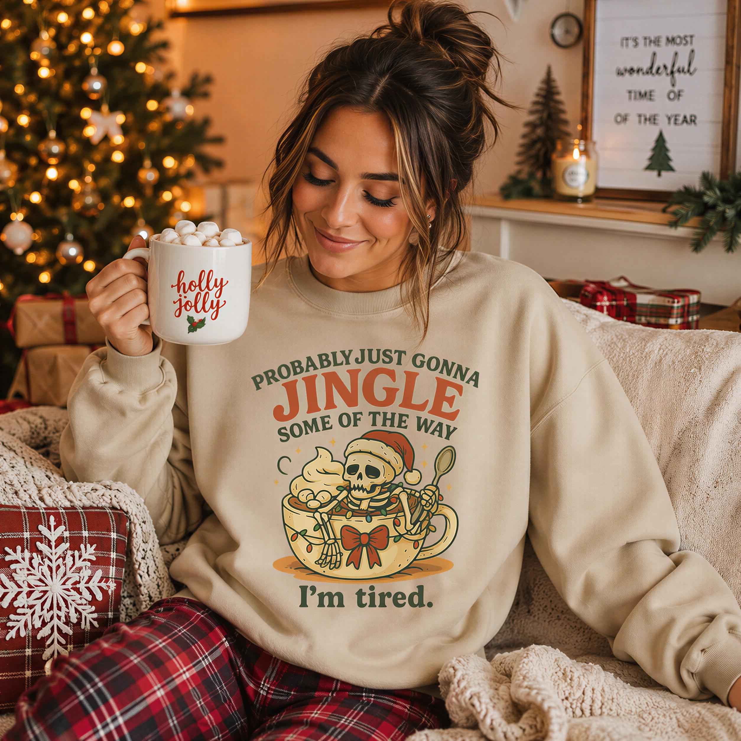 A woman wearing a sweater with a humorous Christmas-themed graphic is sitting on a couch, holding a mug with a mug of marshmallows and a sign that says "It's the most wonderful time of the year".