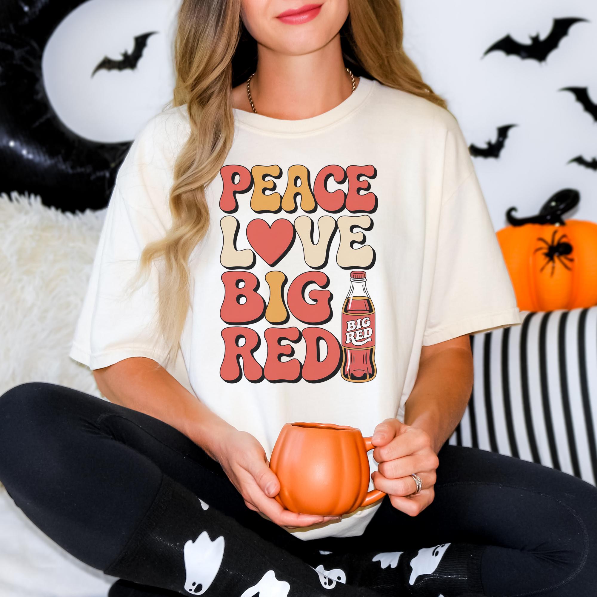 A woman wearing a white t-shirt with a graphic design and holding a pumpkin-shaped mug.