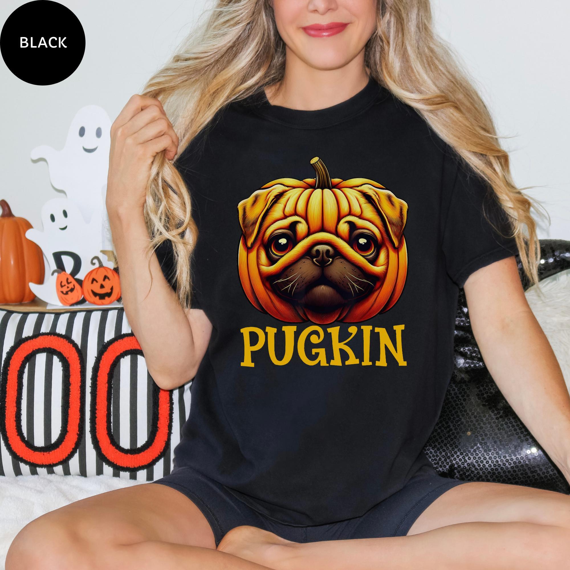 A woman wearing a black t-shirt with a graphic of a pug dog and the word "PUGKIN" printed on it.