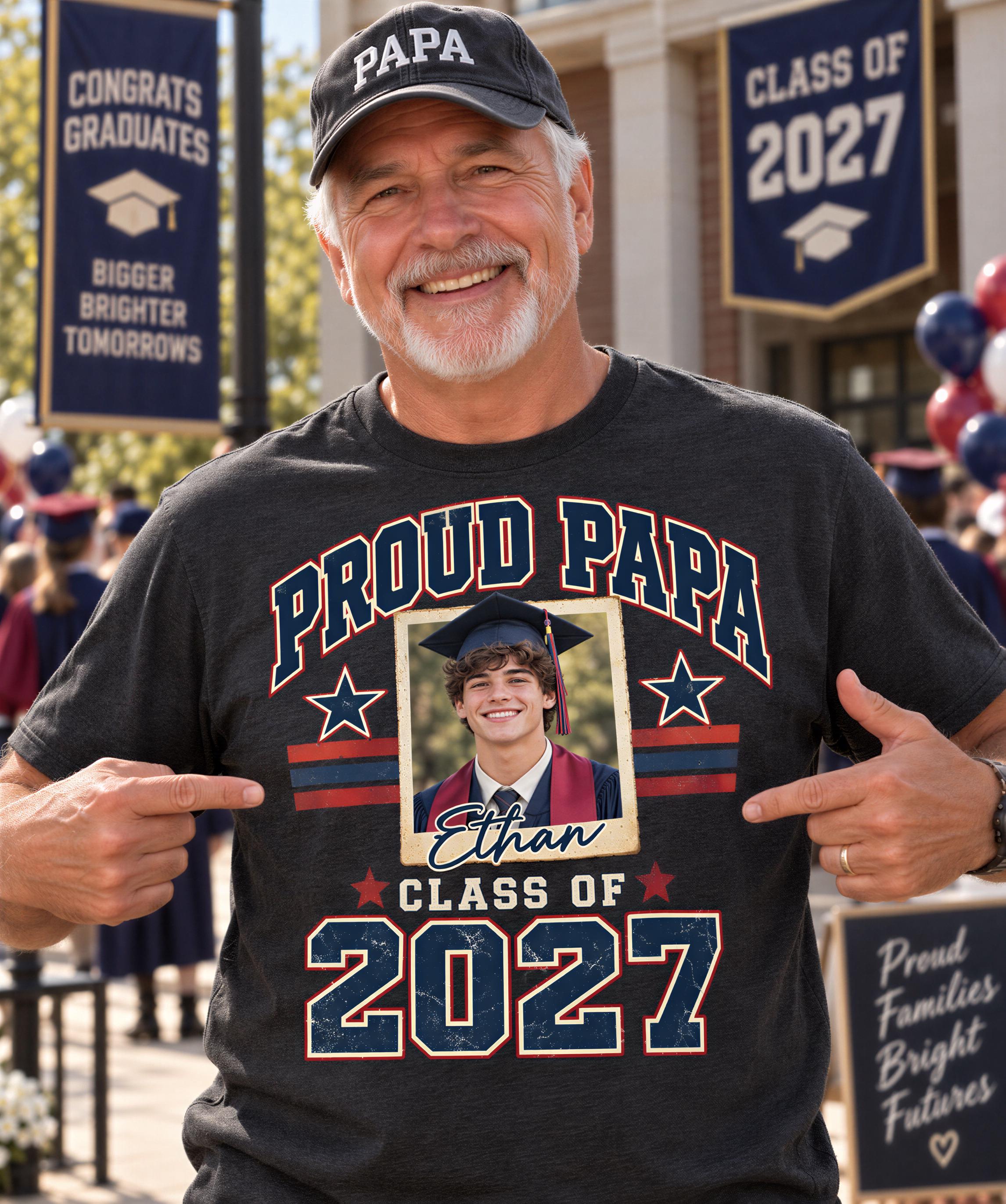 A man wearing a graduation cap and a t-shirt with a graduation cap and a photo of a smiling young man is pointing to his shirt.